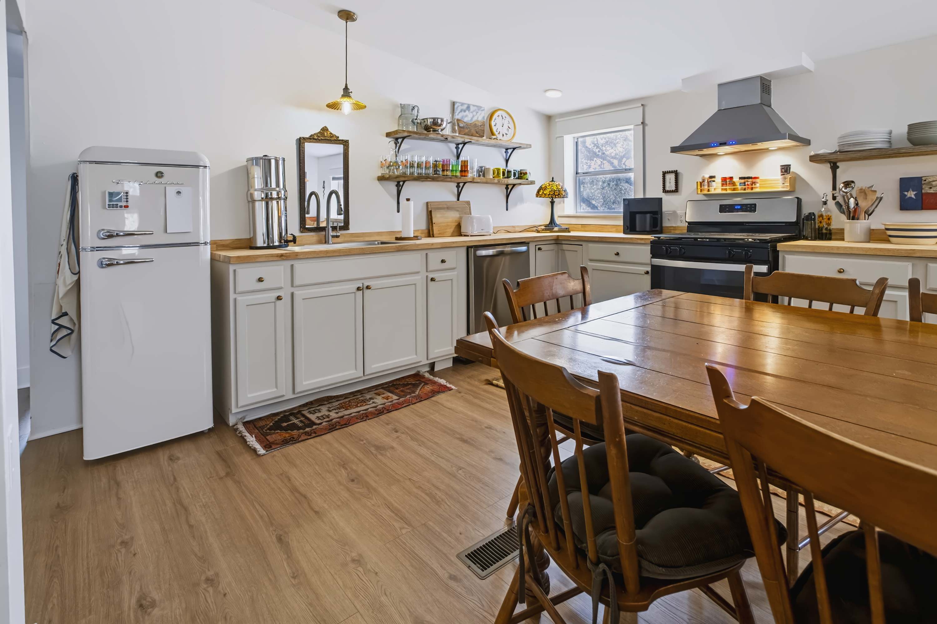 Open kitchen stocked with stay essentials and a dining table with seating for 8