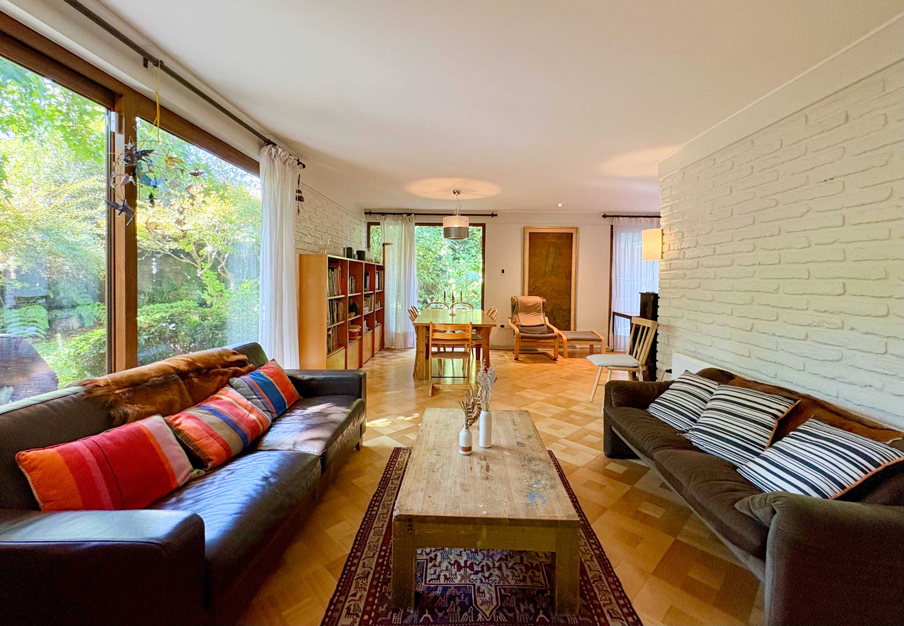 Living room with fireplace and garden-view windows
