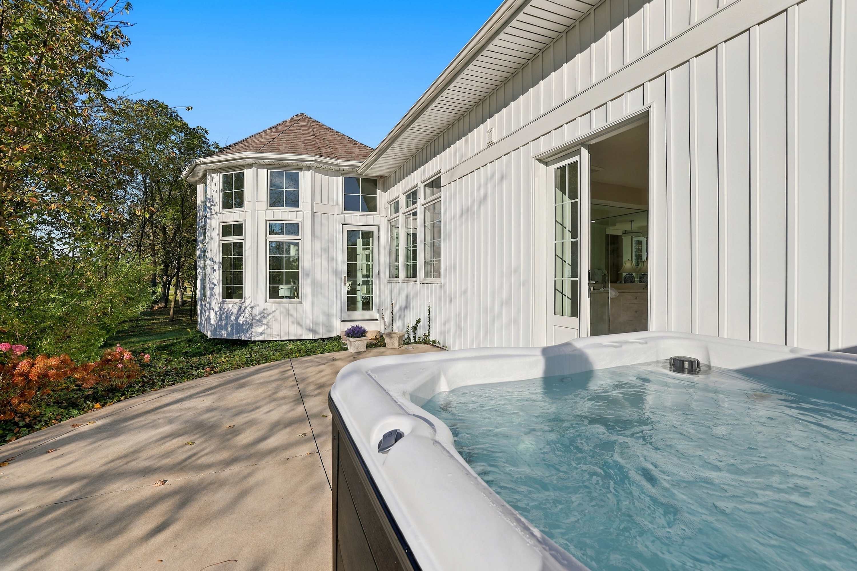 A private Three Oaks hot tub steps from The Barn’s open French doors.