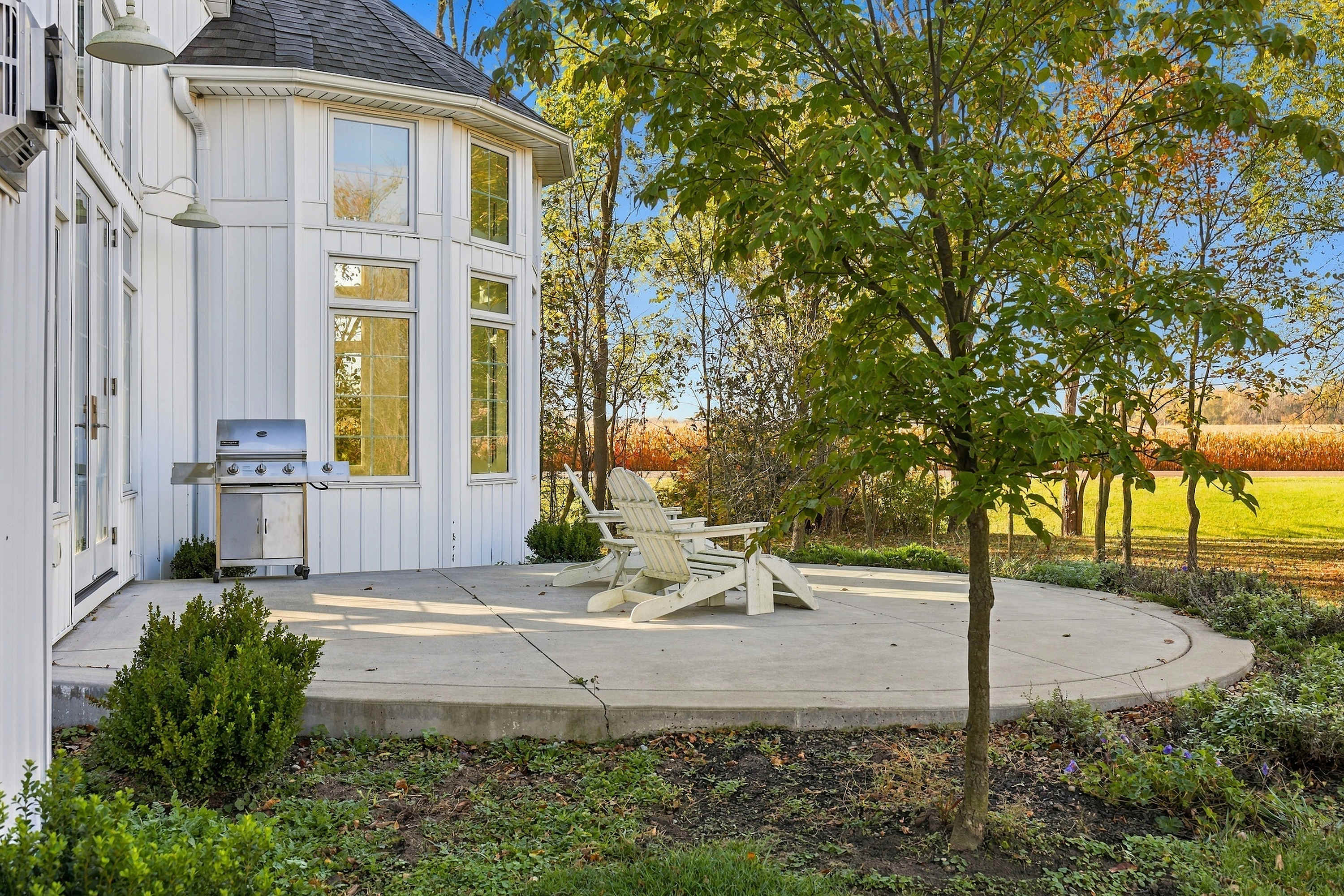 Harbor Country patio with a gas grill, lounge chairs, and farm views.