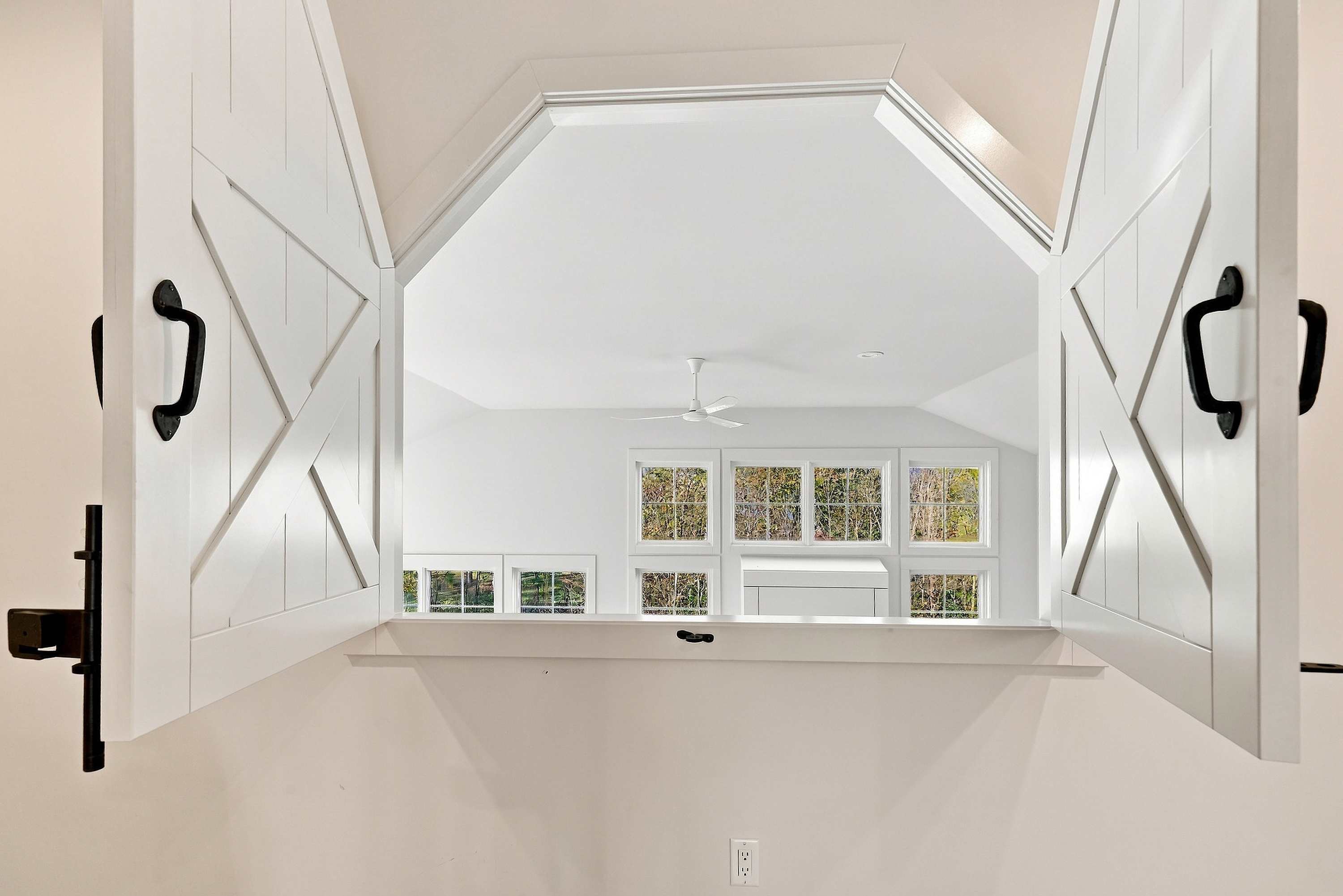 Hayloft shutters in the Three Oaks family room open over the great room.