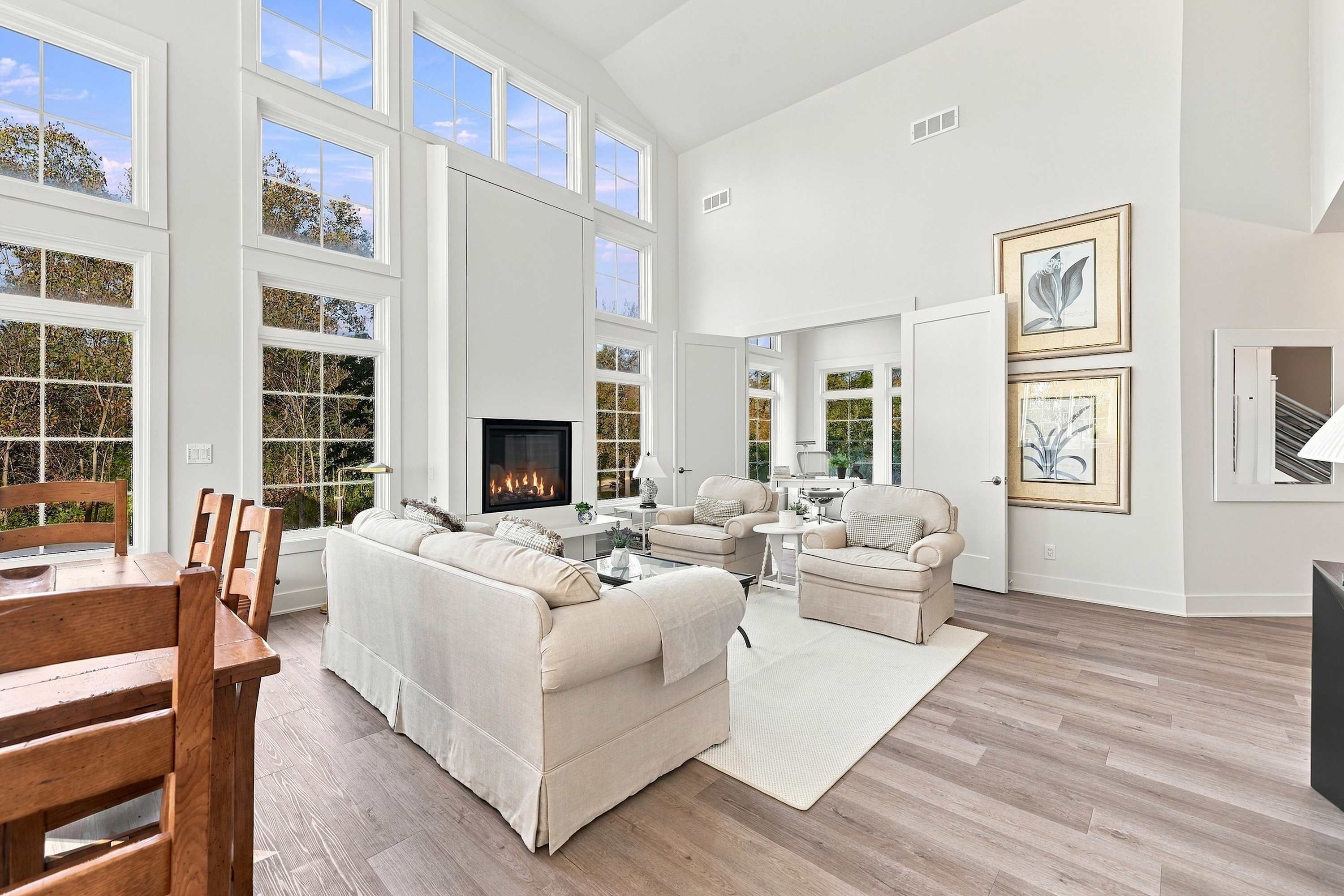 Farmhouse table, fireside seating, and a sunroom office behind the double doors.