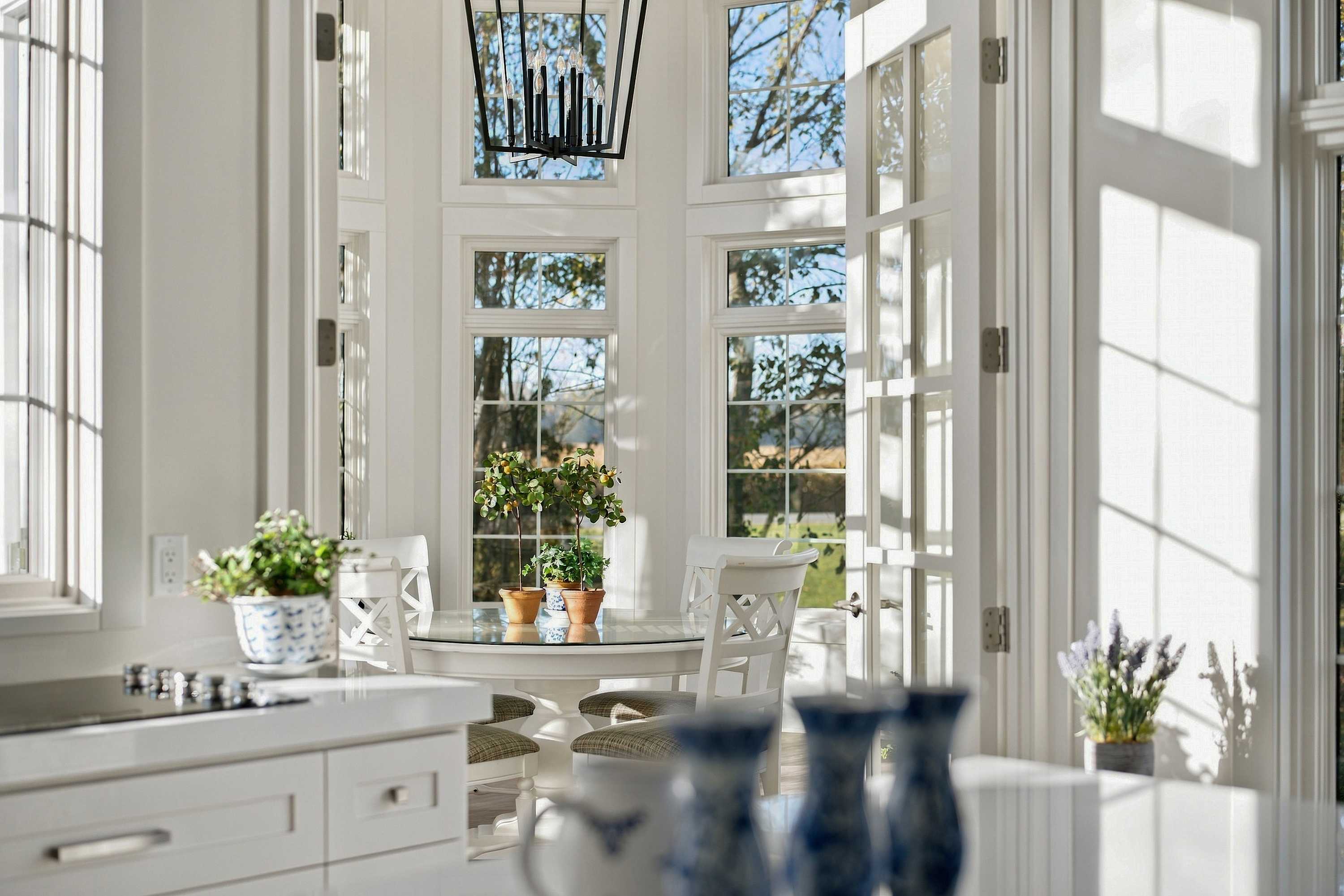 A Three Oaks kitchen view into the turret nook through open French doors.