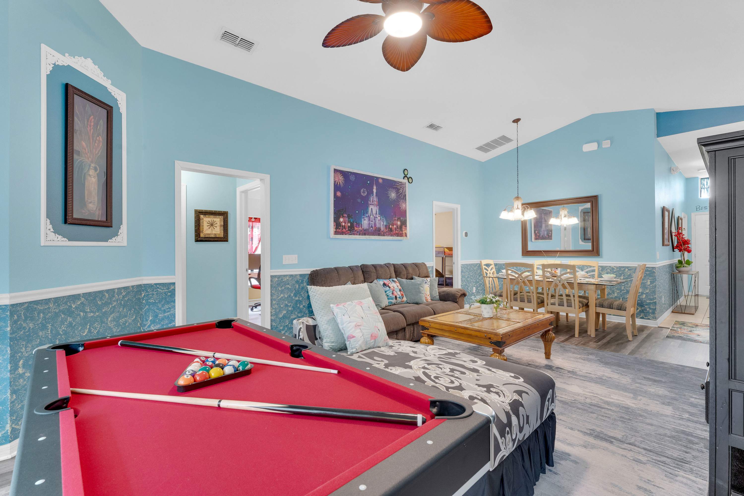Make magical vacation memories with a game of pool in the living room of this Disney-themed home​