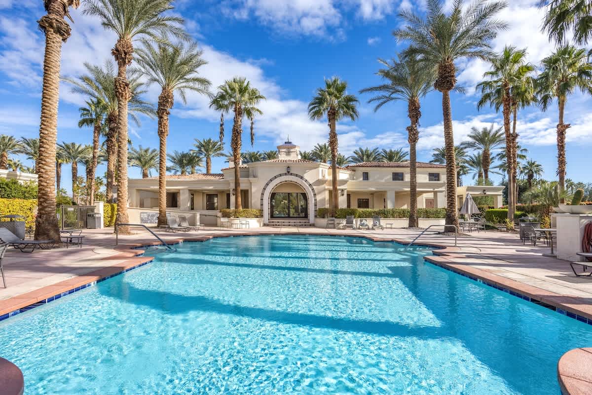 Mediterranean-style pool area with towering palms creates your desert paradise backdrop.