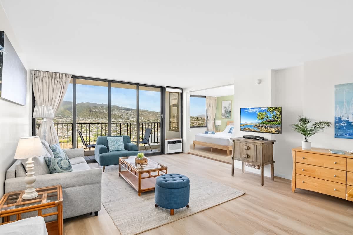 Bright living room with balcony seating and mountain views