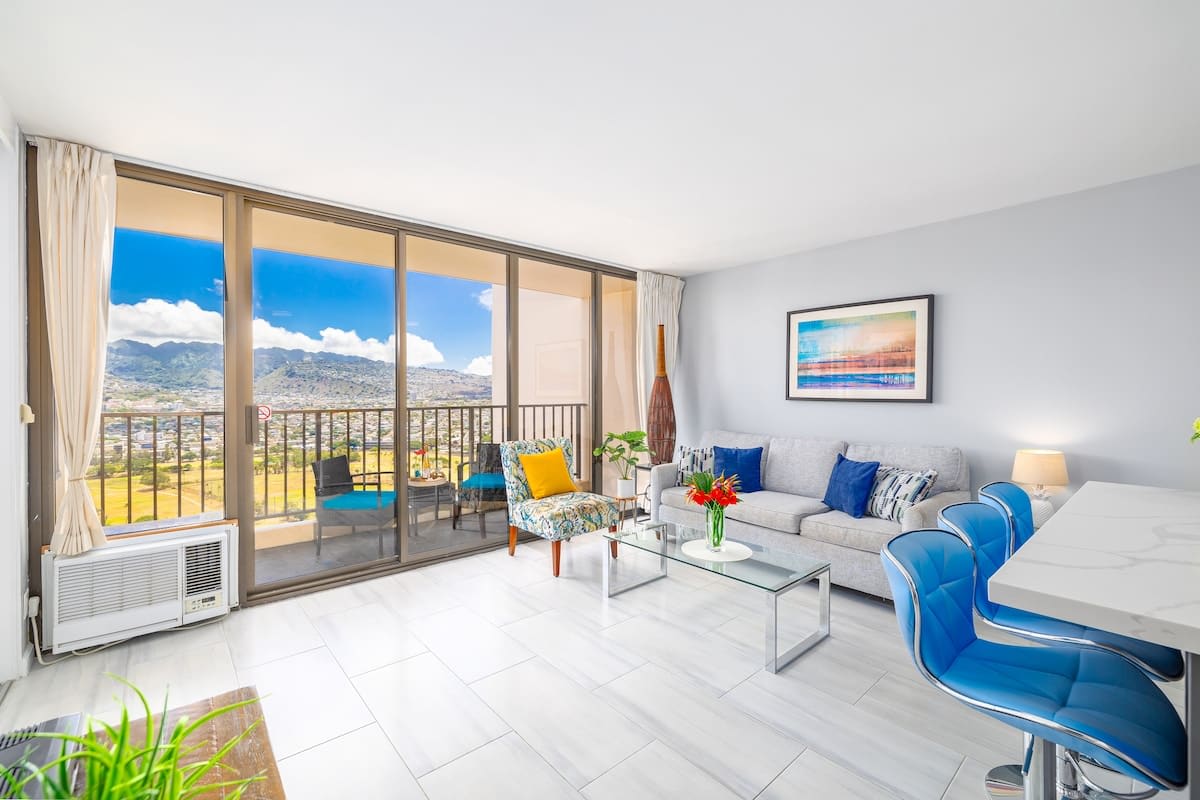 Bright living room with mountain views and a balcony seating area.