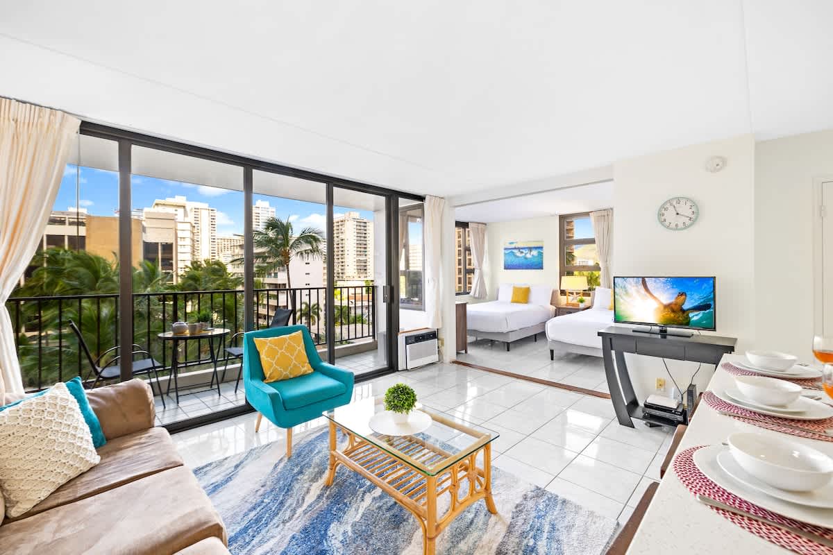 Living room with an open floor plan, fully equipped kitchen, and a balcony!