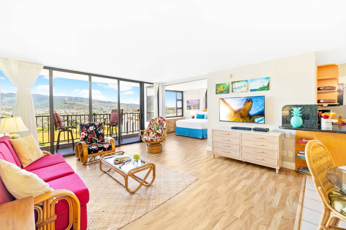 This vibrantly decorated condo features a living area with a pull-out sleeper sofa, a 51" Smart TV, and direct access to a balcony offering expansive mountain and city views.