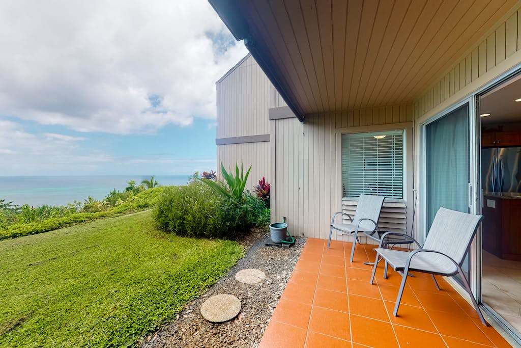 Relaxing patio offers open-air seating overlooking manicured lawns and mountains