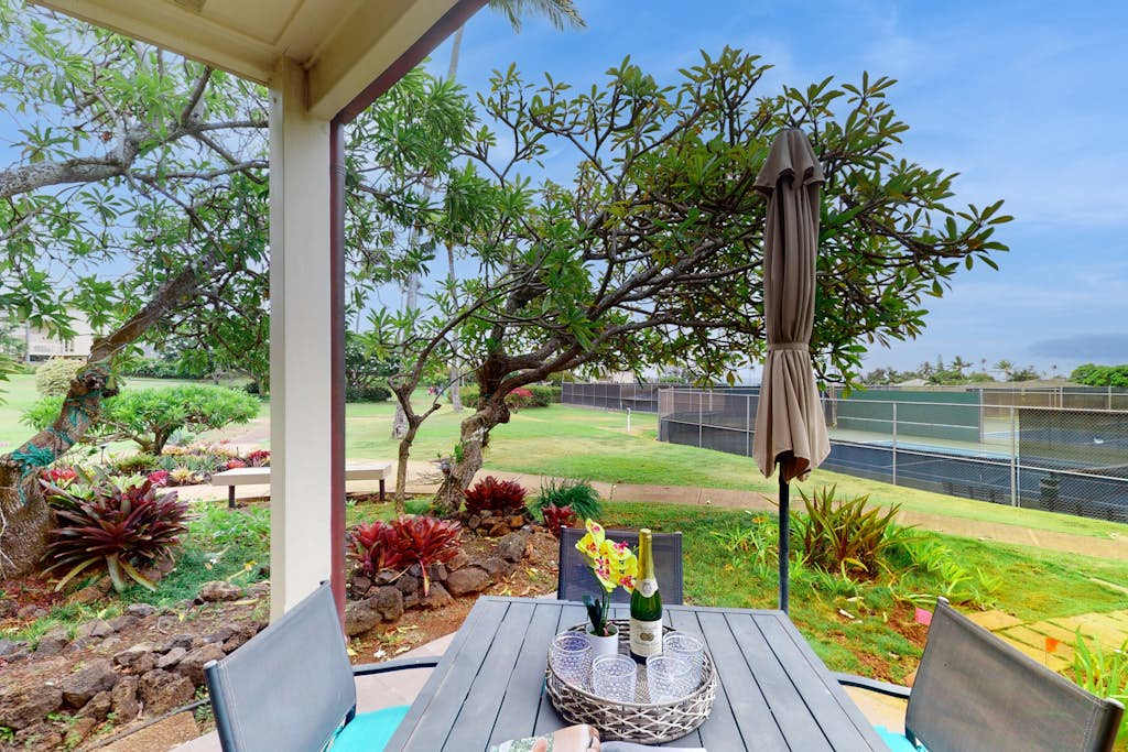 Covered outdoor dining area surrounded by lush tropical landscaping