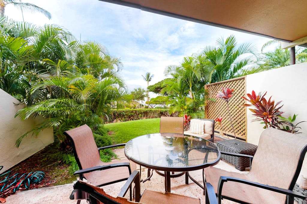 Covered patio seating overlooks tropical greenery for relaxed island mornings