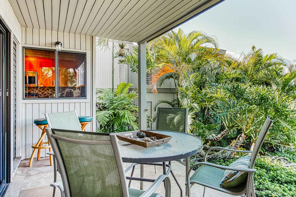 Covered Patio Dining Set Surrounded by Tropical Garden Greenery