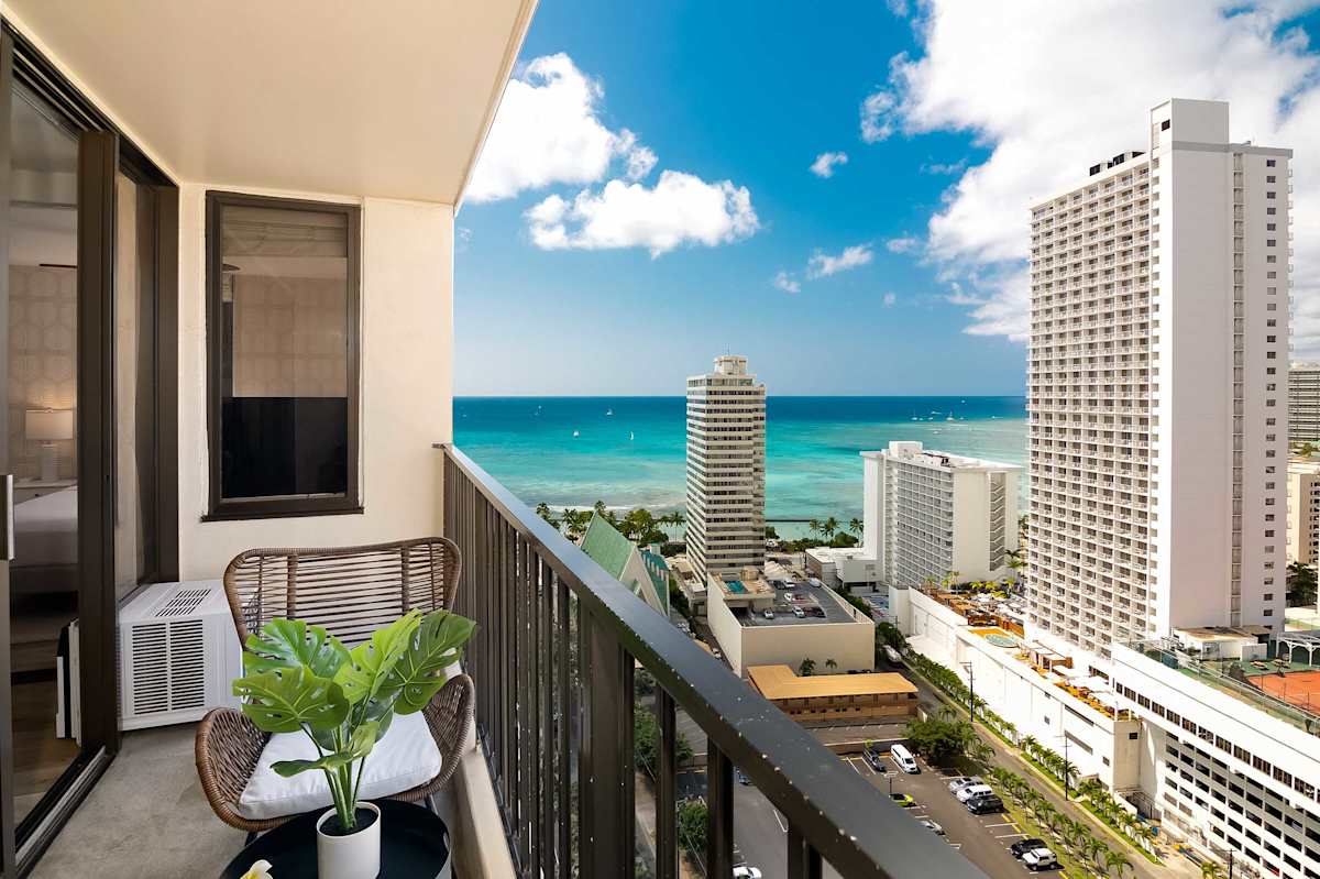 Private balcony w/ seating overlooking Waikiki skyline & turquoise ocean beyond