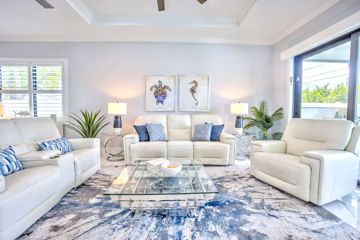 Beautiful Living Room With Cozy Seating Area;  Flat TV;  Large Windows; Entrance to Pool Area;  Perfect Atmosphere For Relaxation And Social Gatherings