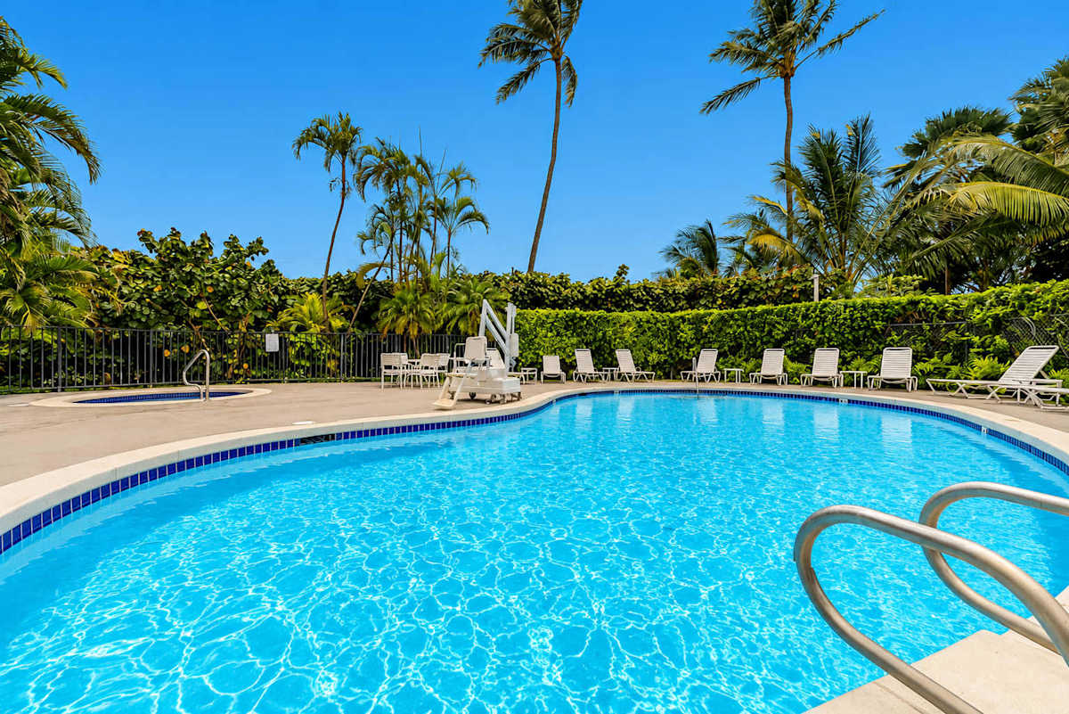 Resort-Style Outdoor Swimming Pool and Hot Tub Area Surrounded by Palm Trees