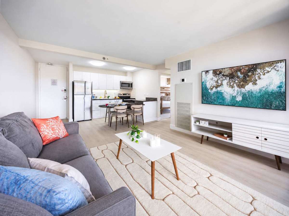 Enjoy seamless open-concept living anchored by a spacious lounge with a 65" Smart TV that flows effortlessly into the modern dining and kitchen area.