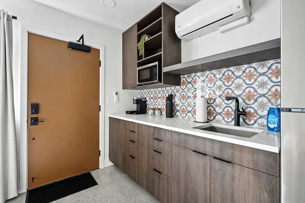 A small kitchenette with a microwave, sink, and coffee maker