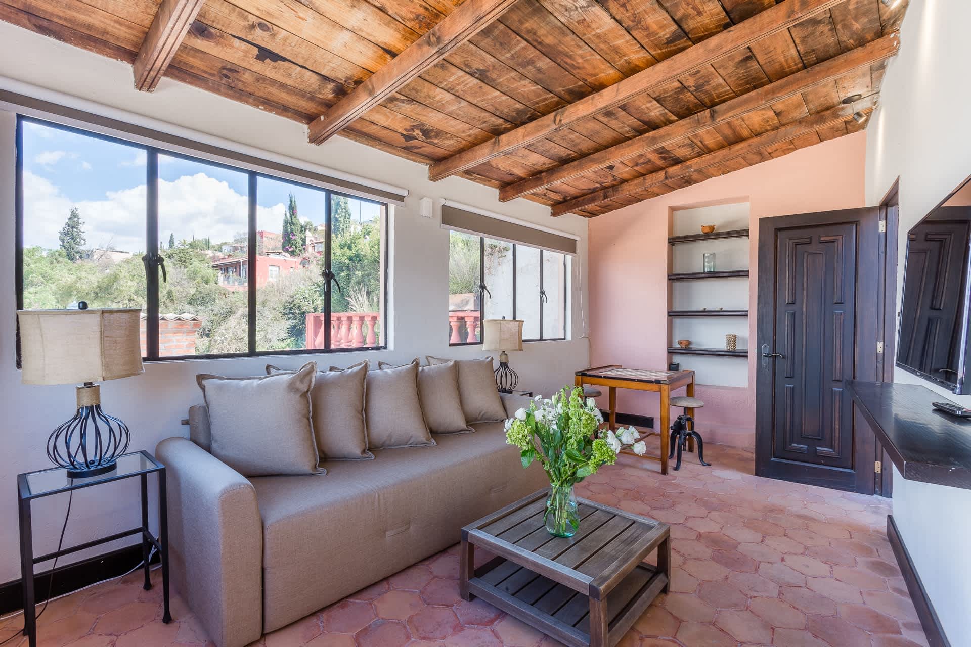 Living room with sofa bed and exposed wood beam ceiling
