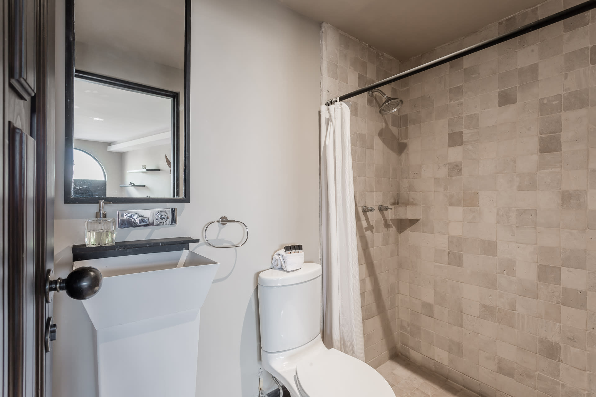 Ensuite bathroom with textured tile shower and vanity mirror