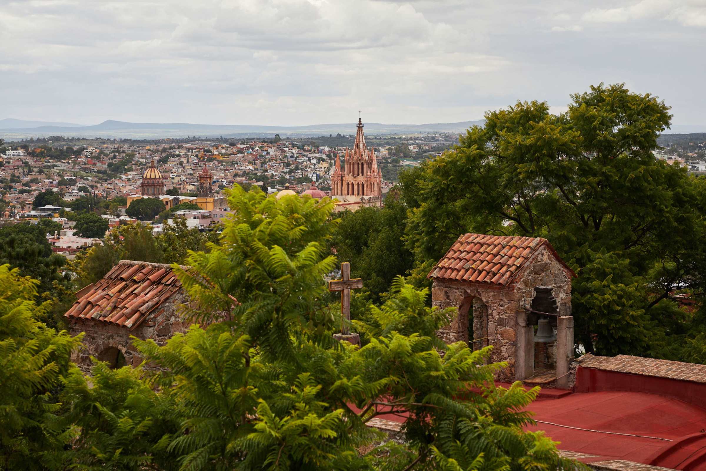 Balcony view of terracotta rooftops and the Parroquia tower