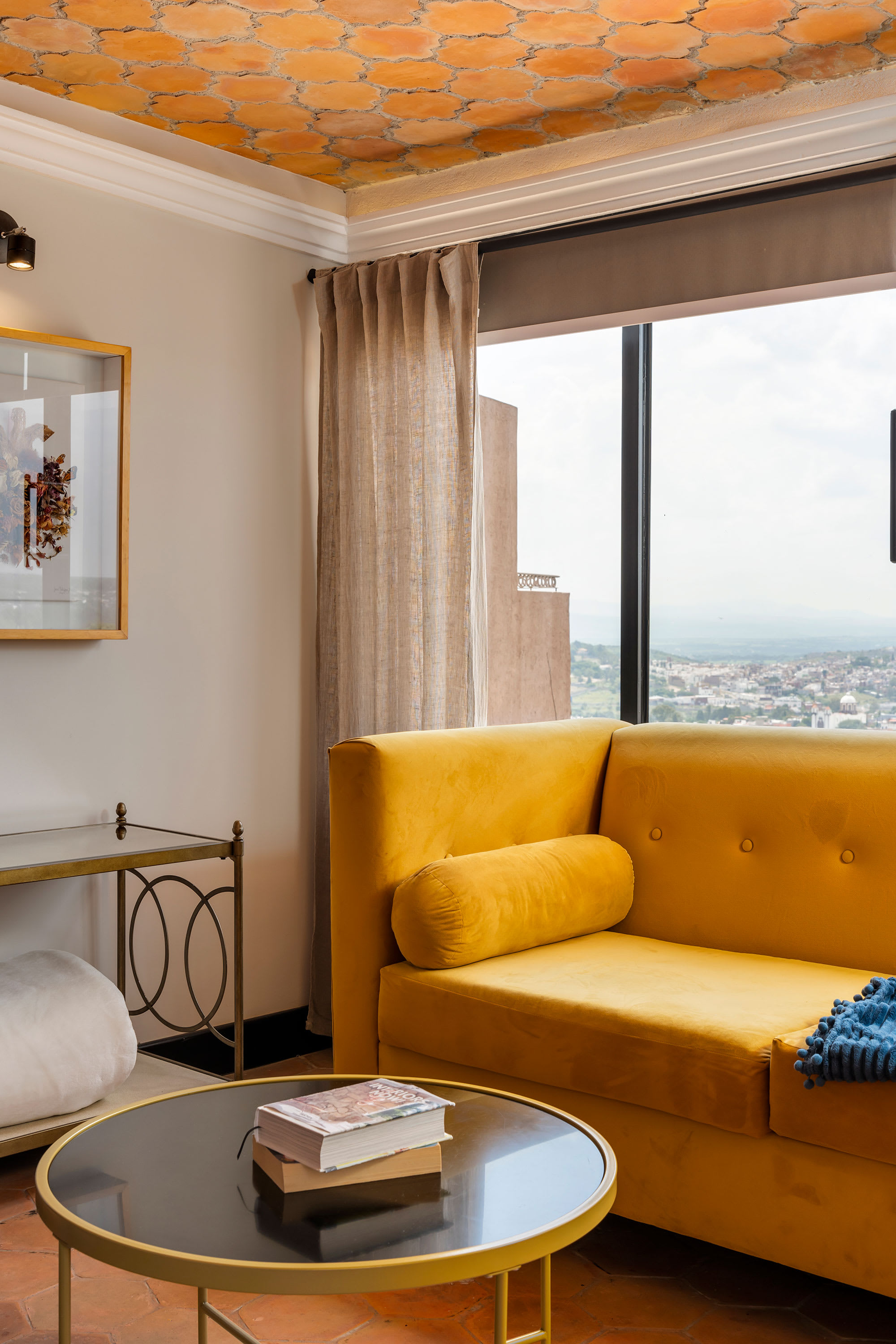 Sitting nook with a yellow sofa and city view window