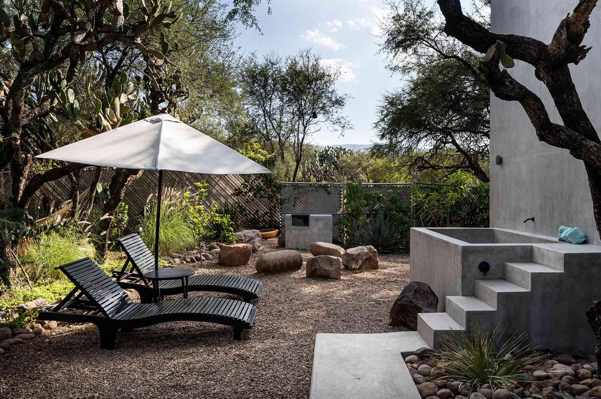 Lounge chairs and an oversized soaking tub sit outside.