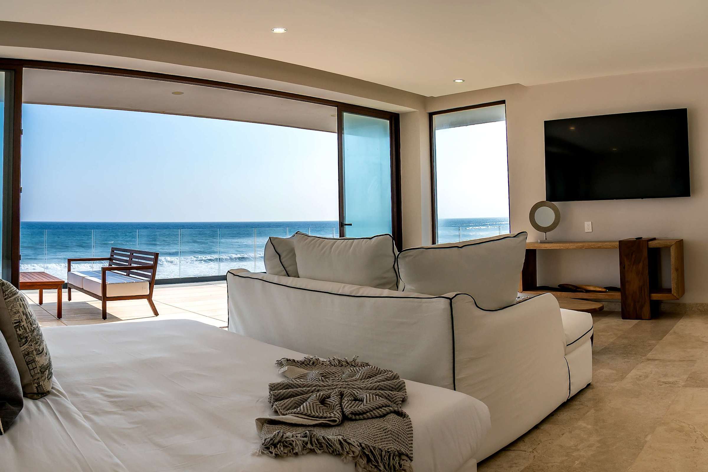 King bedroom with floor-to-ceiling ocean views, smart TV, and a king bed — fall asleep to the sound of the waves