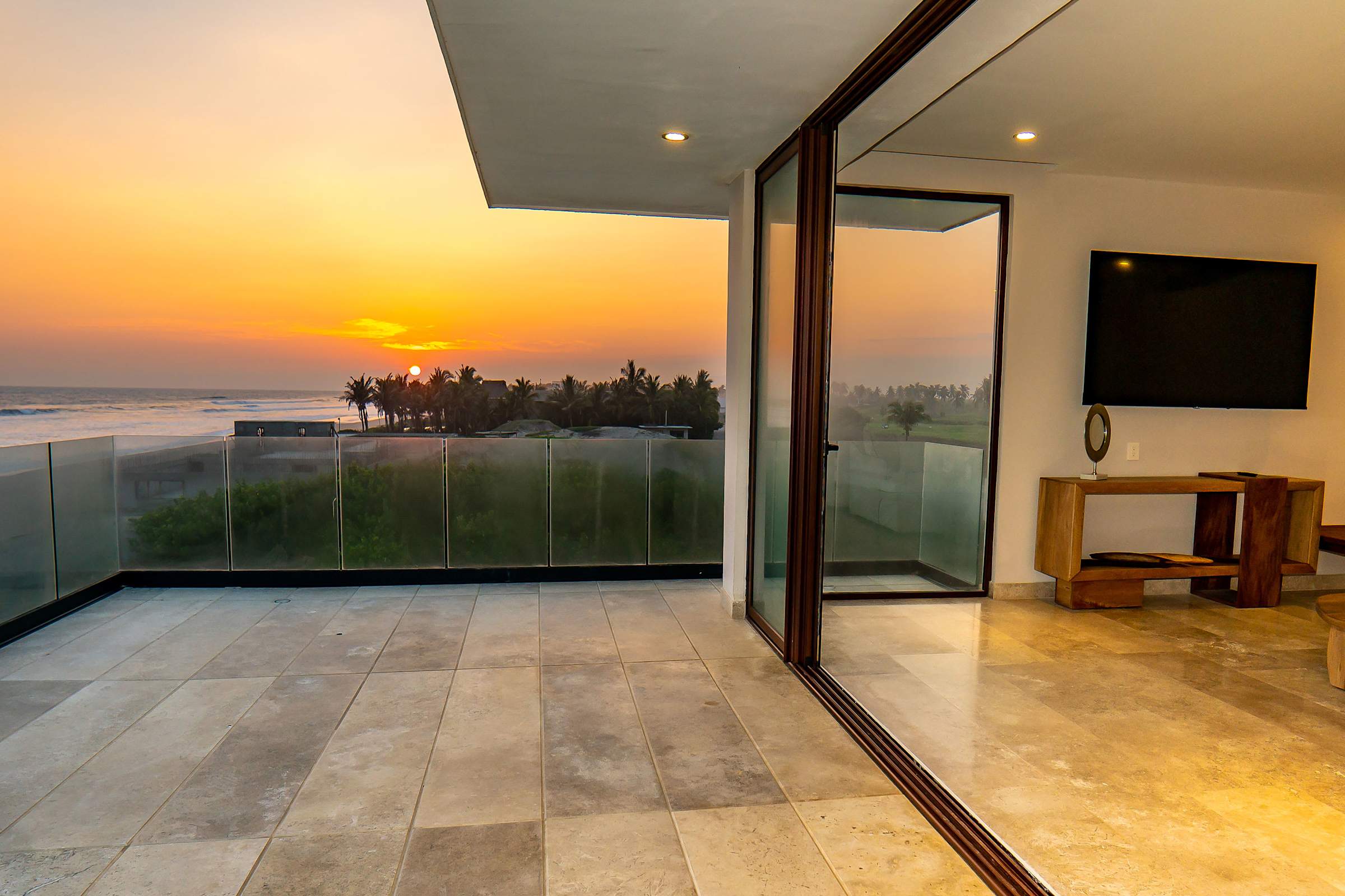 Private balcony off Bedroom 1 bathed in a fiery sunset glow — the perfect spot for a romantic evening drink