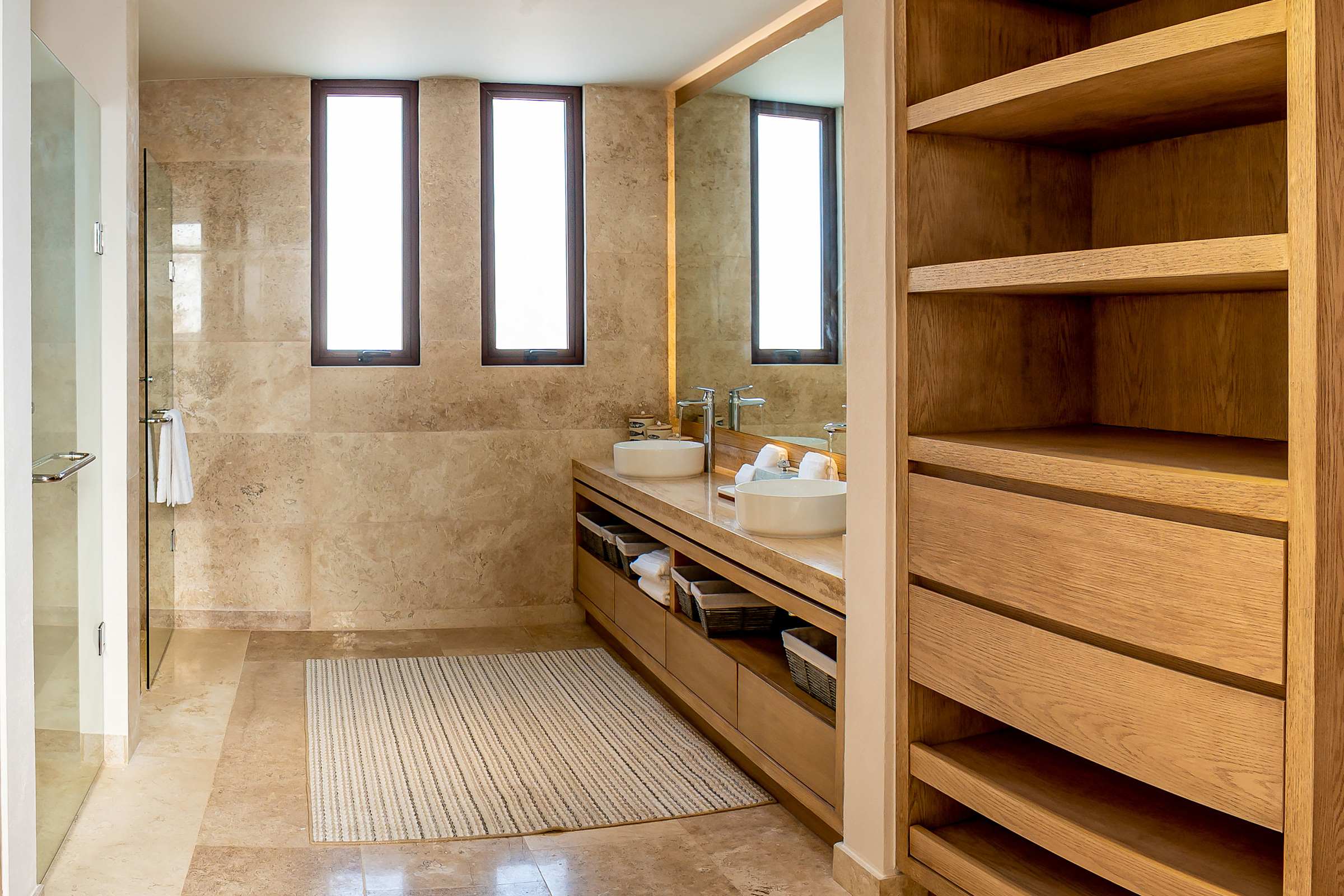 Full Bathroom 4 with custom built-in wood shelving, warm ambient lighting, generous storage and shower