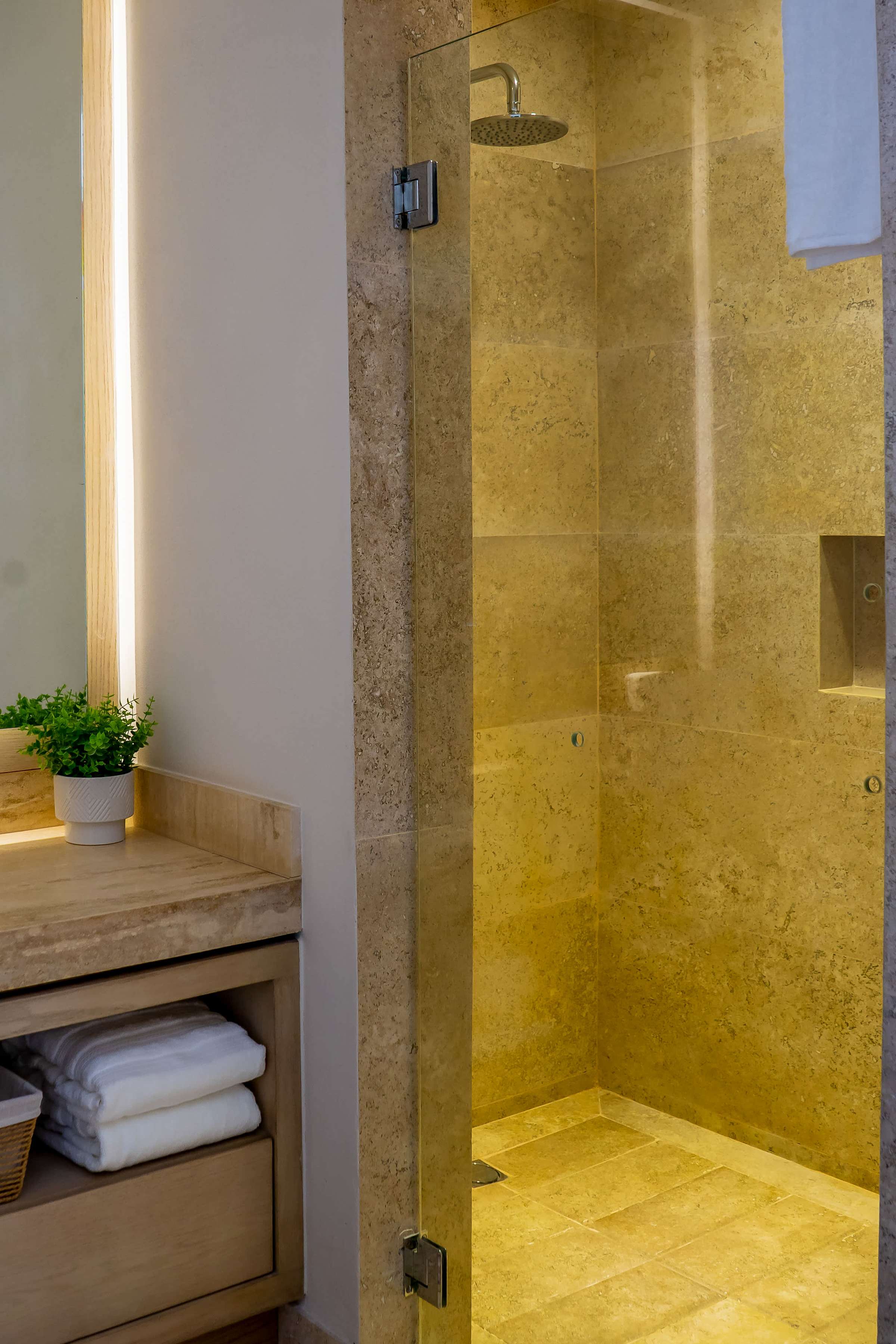Glass shower in Full Bathroom 3 with gleaming amber tiles, rainfall showerhead, and fluffy towels
