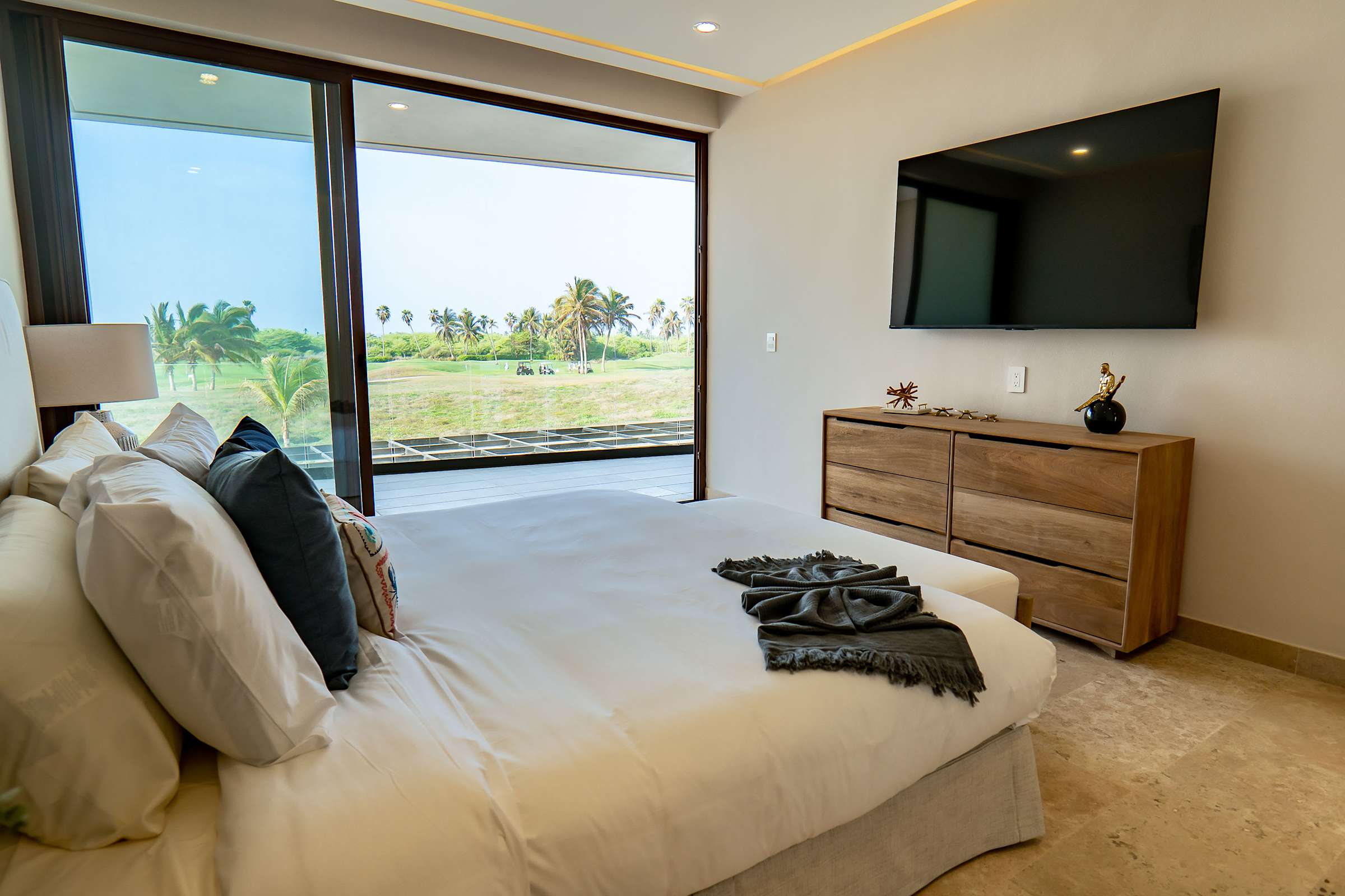 Bedroom 4 with a flat-screen TV, garden terrace access, and modern wood furnishings