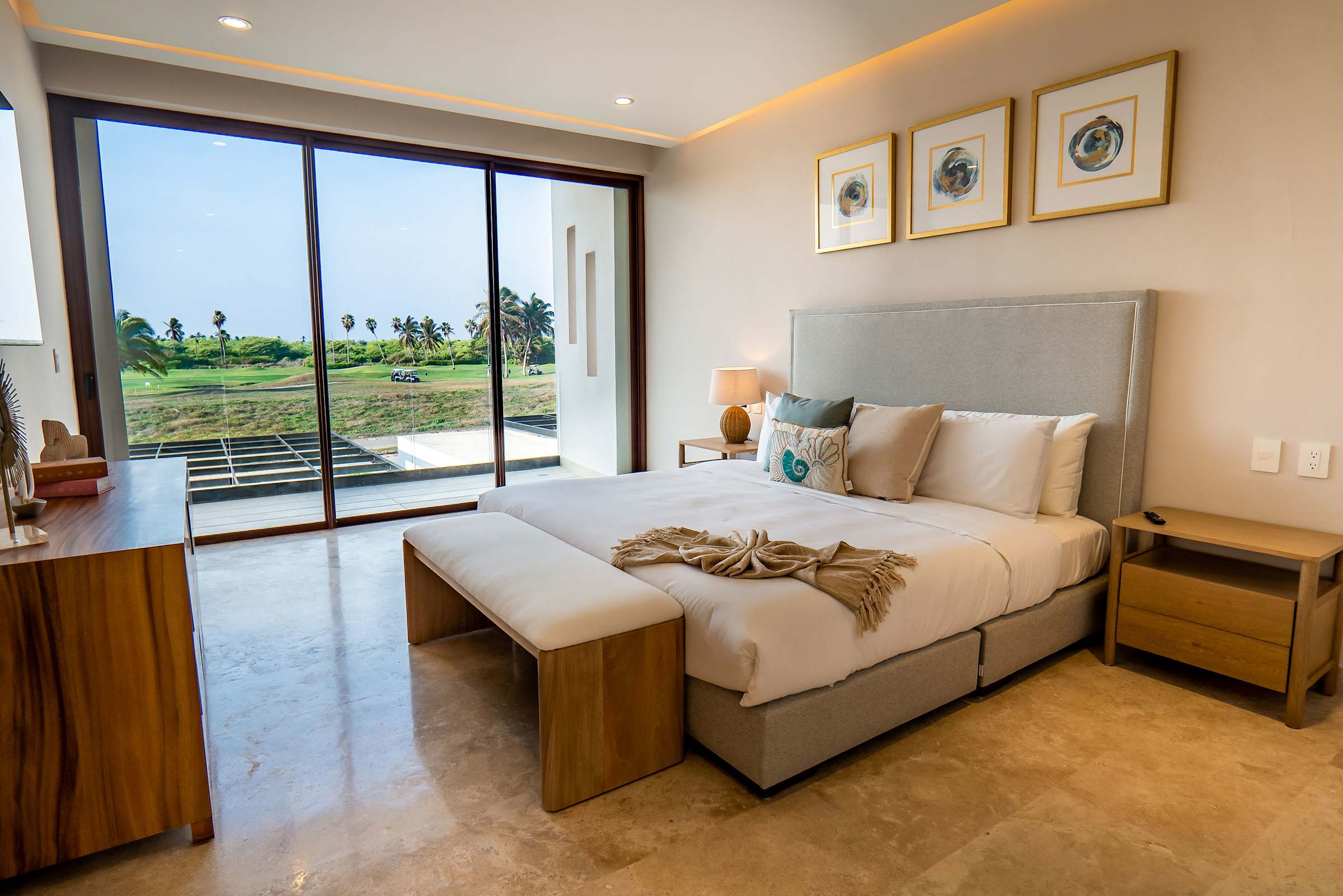 Bedroom 5 with a plush king bed, contemporary decor, and golf course views through sliding glass doors