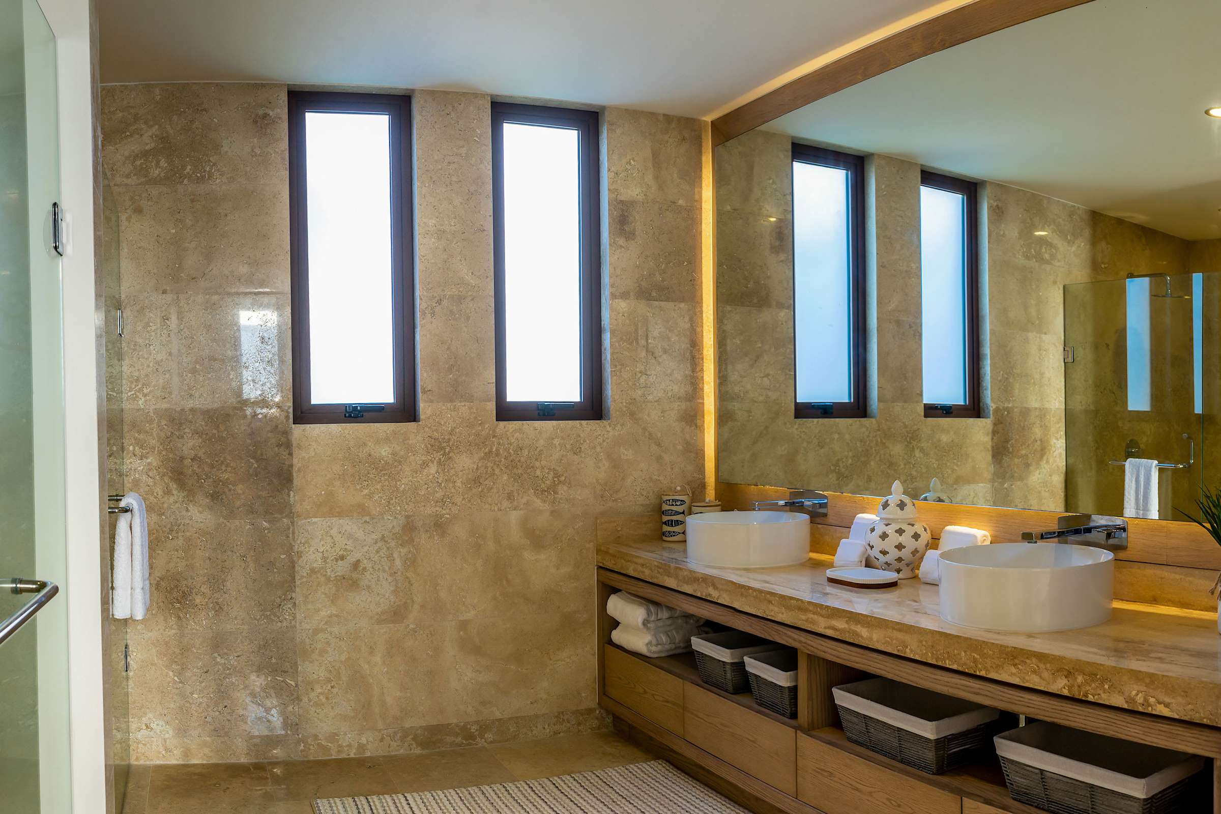 Full Bathroom 6 with a stone-surround double vanity, bright natural light, and upscale fixtures