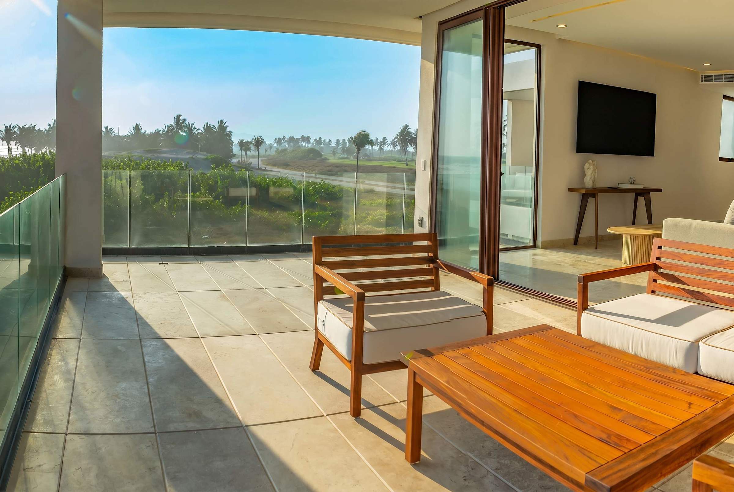 Outdoor lounge on Bedroom 6 terrace with comfortable sofa, TV, and sweeping ocean and pool views
