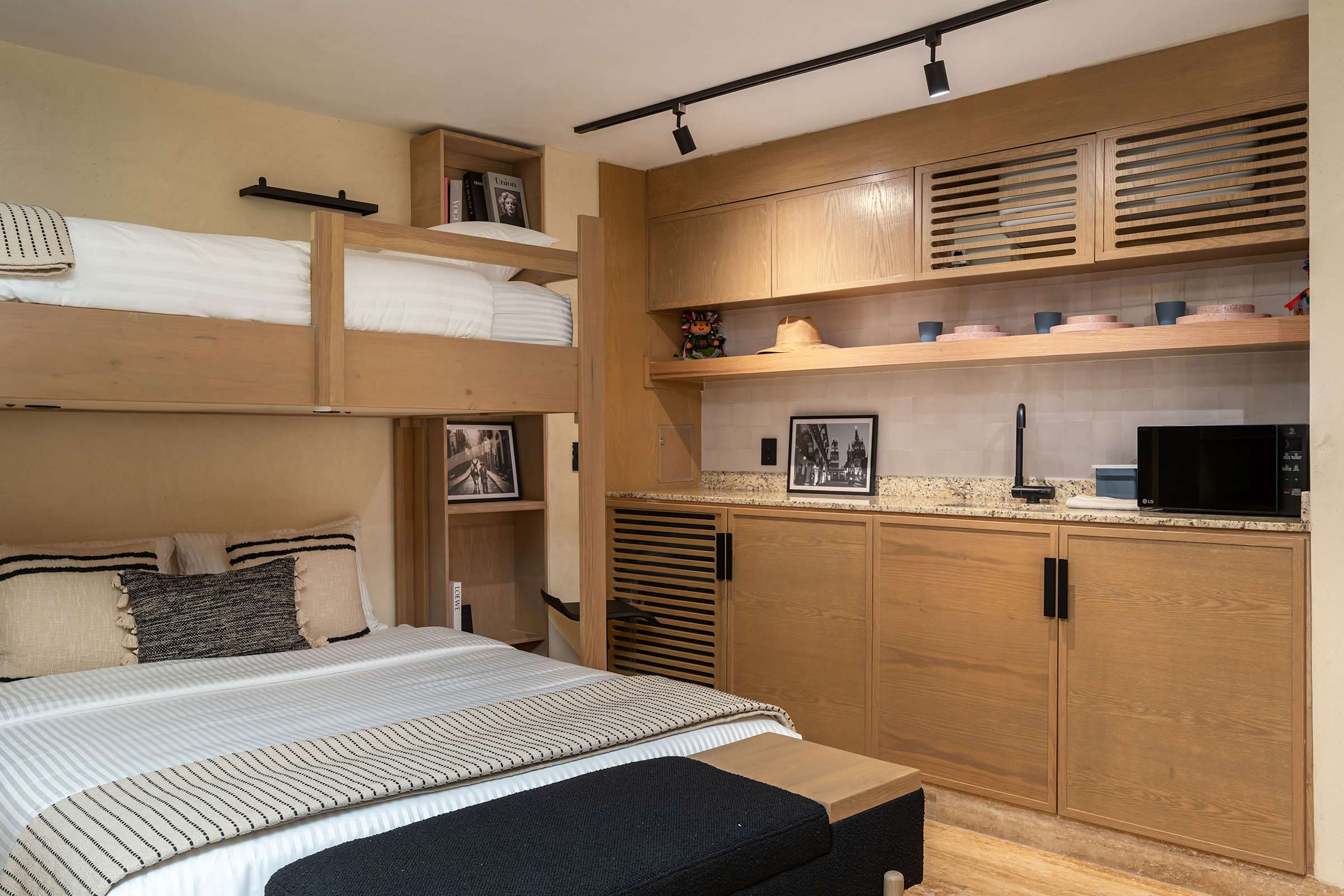 Bedroom kitchenette with warm wood cabinetry, a faucet sink, and microwave.