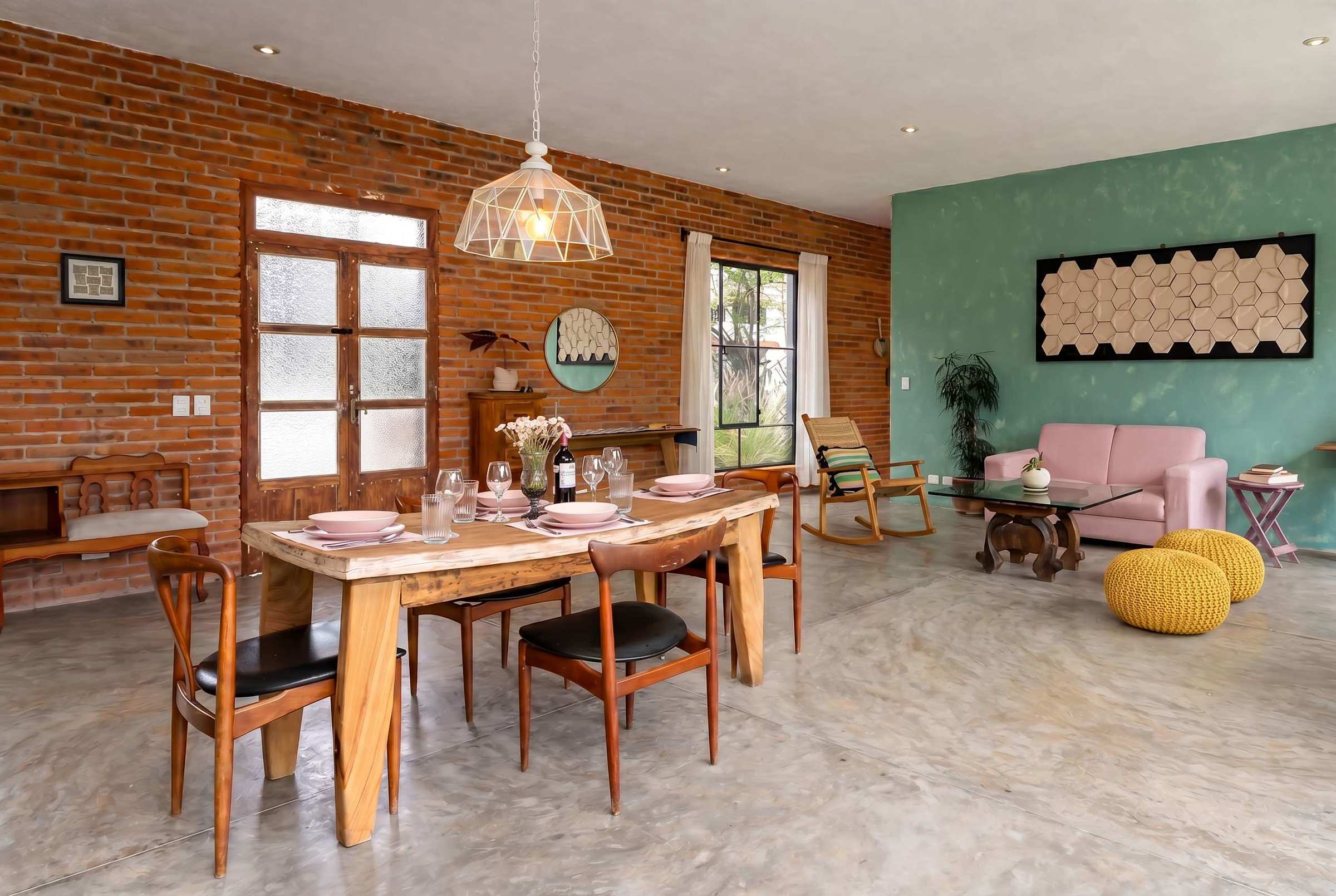 Spacious open-plan living and dining area with polished concrete floors and garden windows