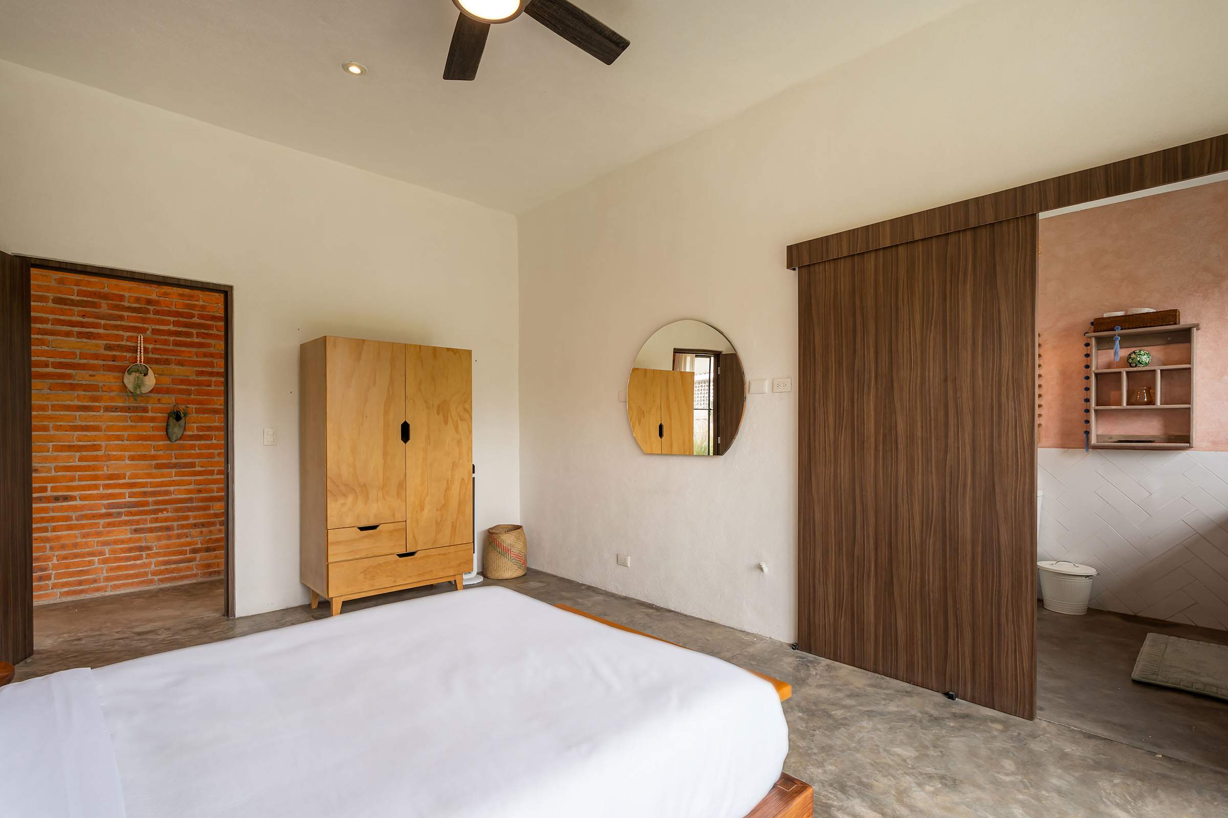Queen bedroom with wardrobe, ceiling fan, and sliding barn door leading to ensuite bathroom