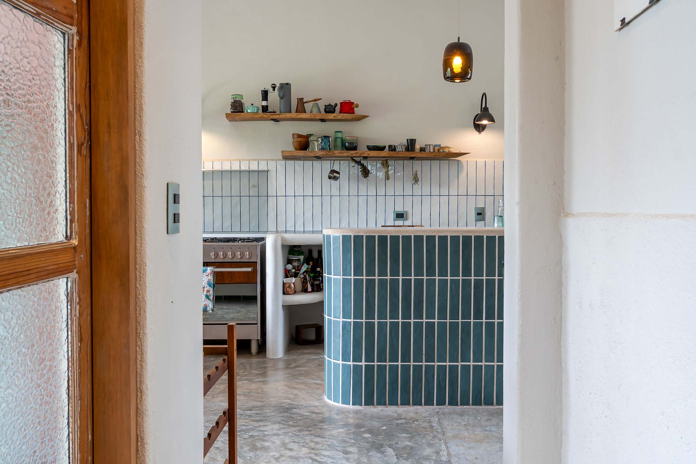 Kitchen entrance with green-tiled island