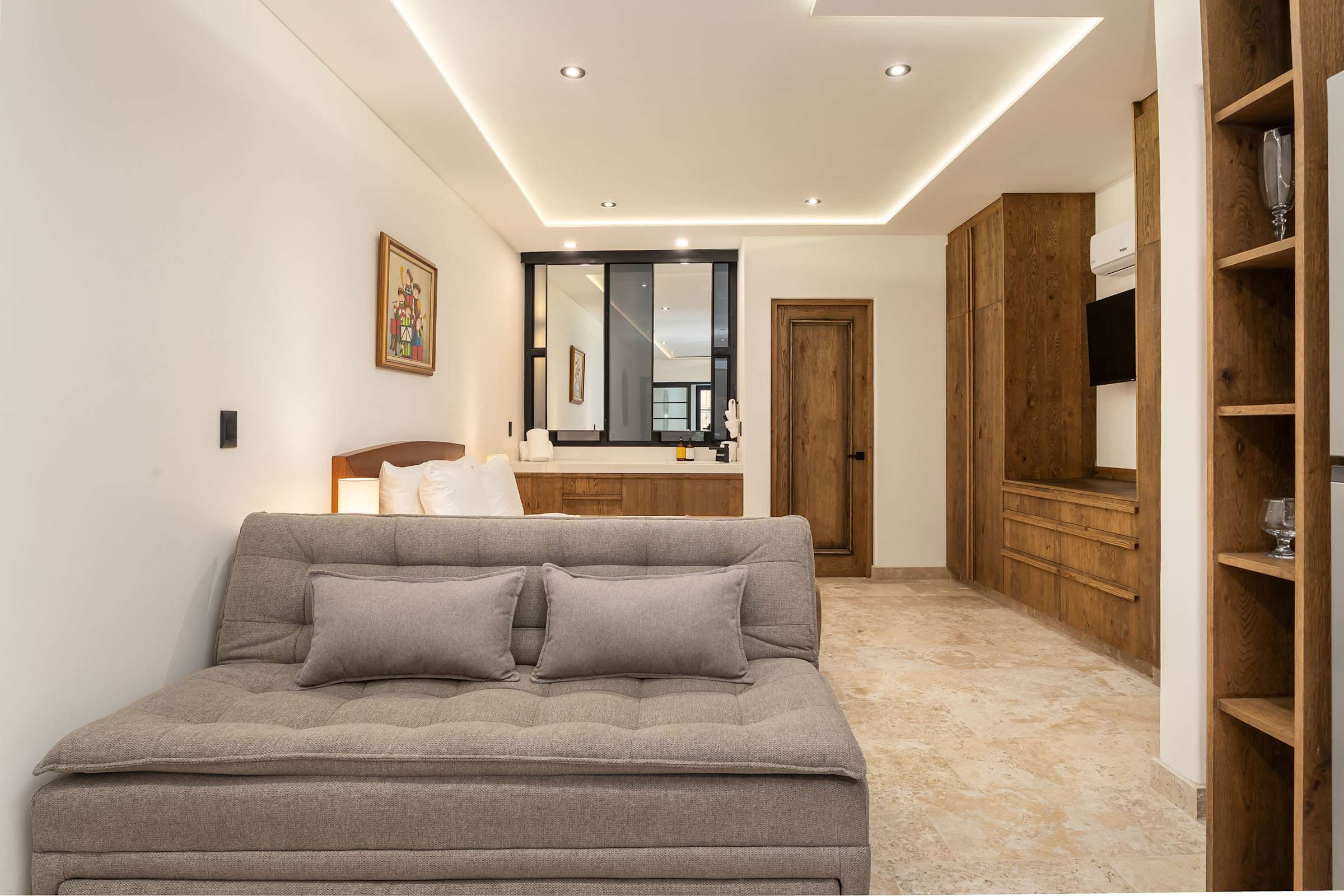 Living area with sofa bed, Smart TV, and wooden cabinetry