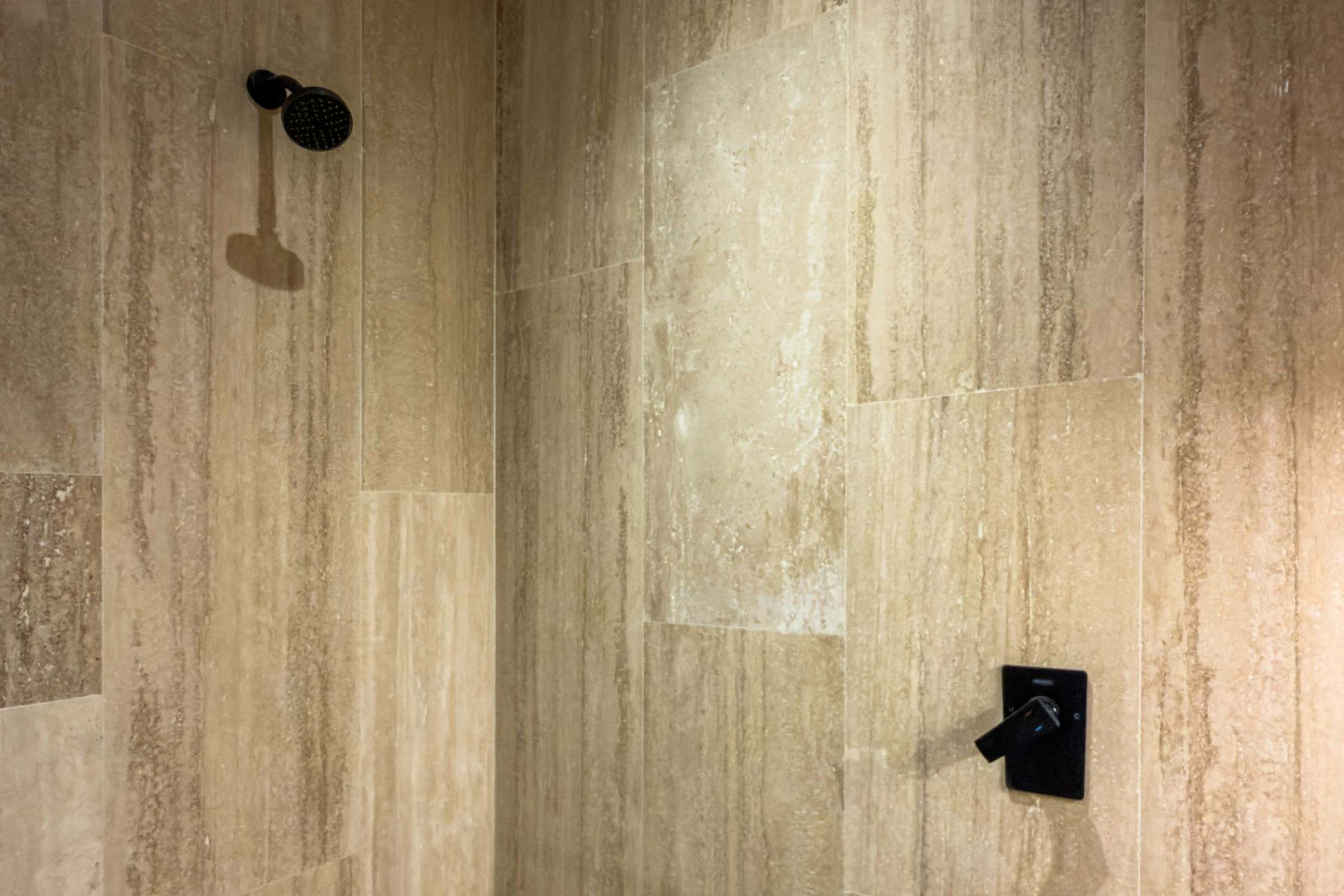 Walk-in shower with stone tile walls and modern fixtures