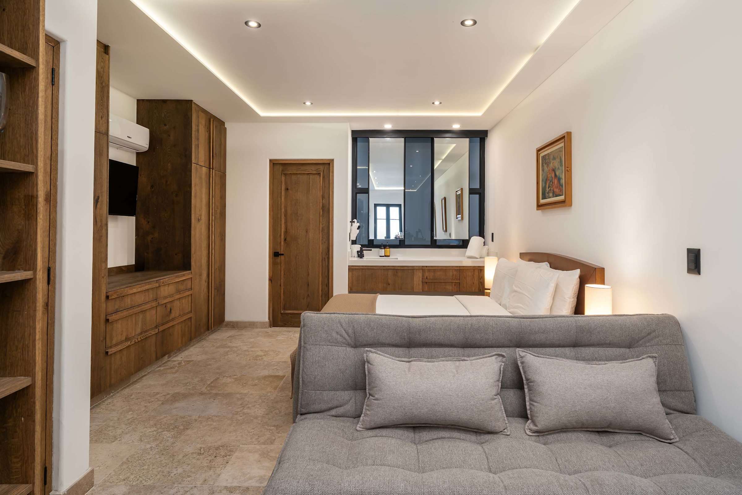 Living area with sofa bed, wood wardrobe, Smart TV, and open layout