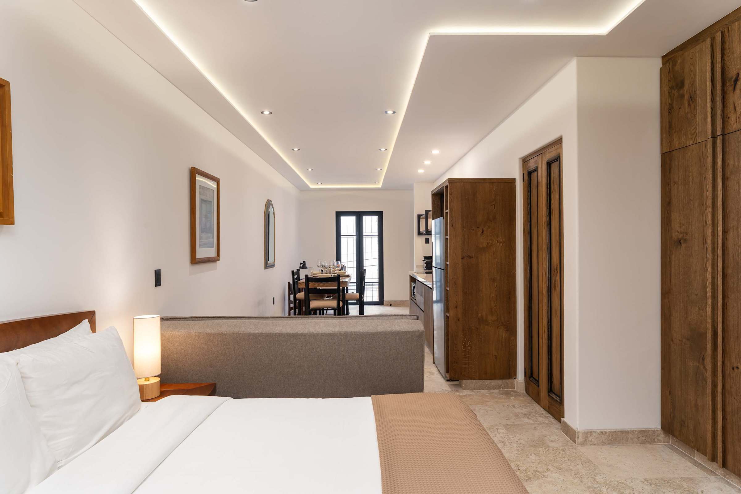 Bedroom with queen bed, open loft layout, and kitchen in background