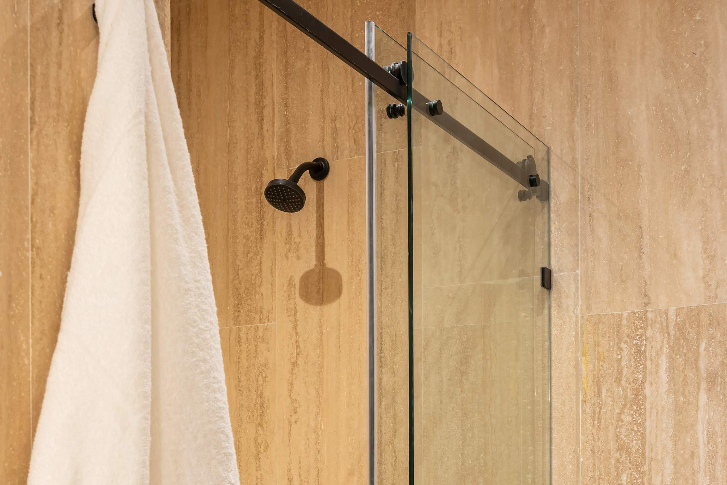 Walk-in shower with stone tile walls and modern fixtures