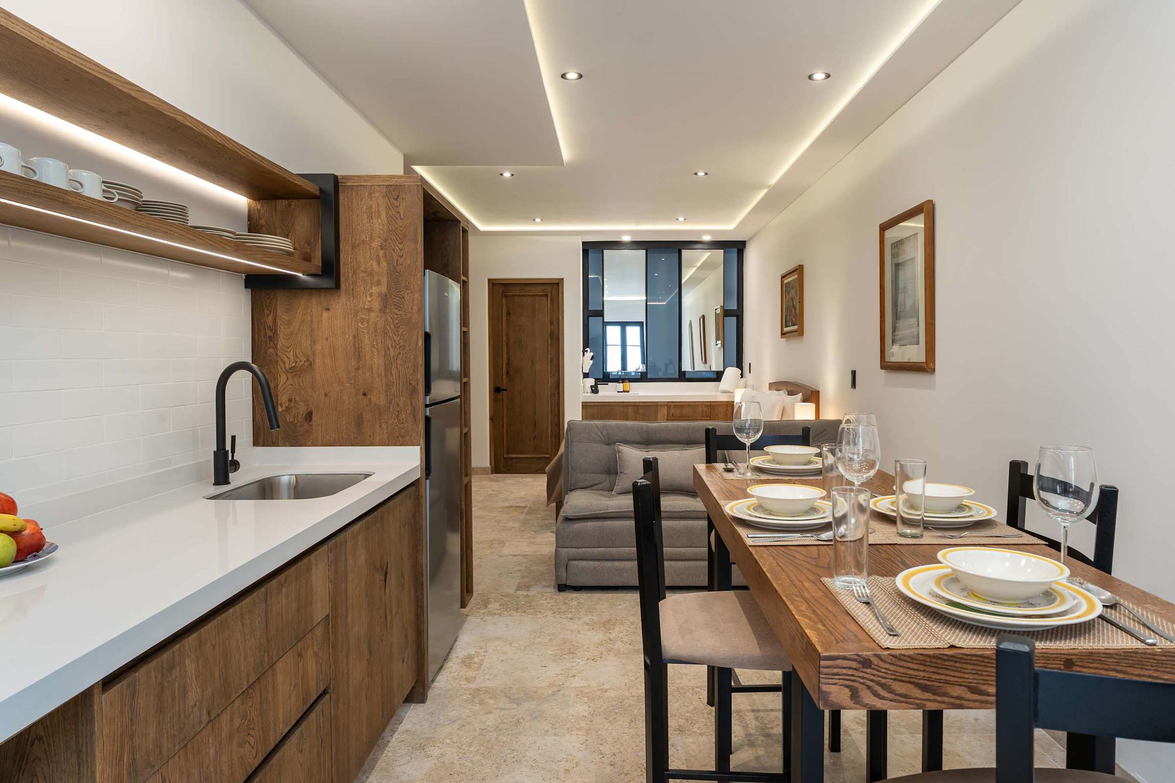 Open-plan kitchen with sink, refrigerator, dining table, and living area