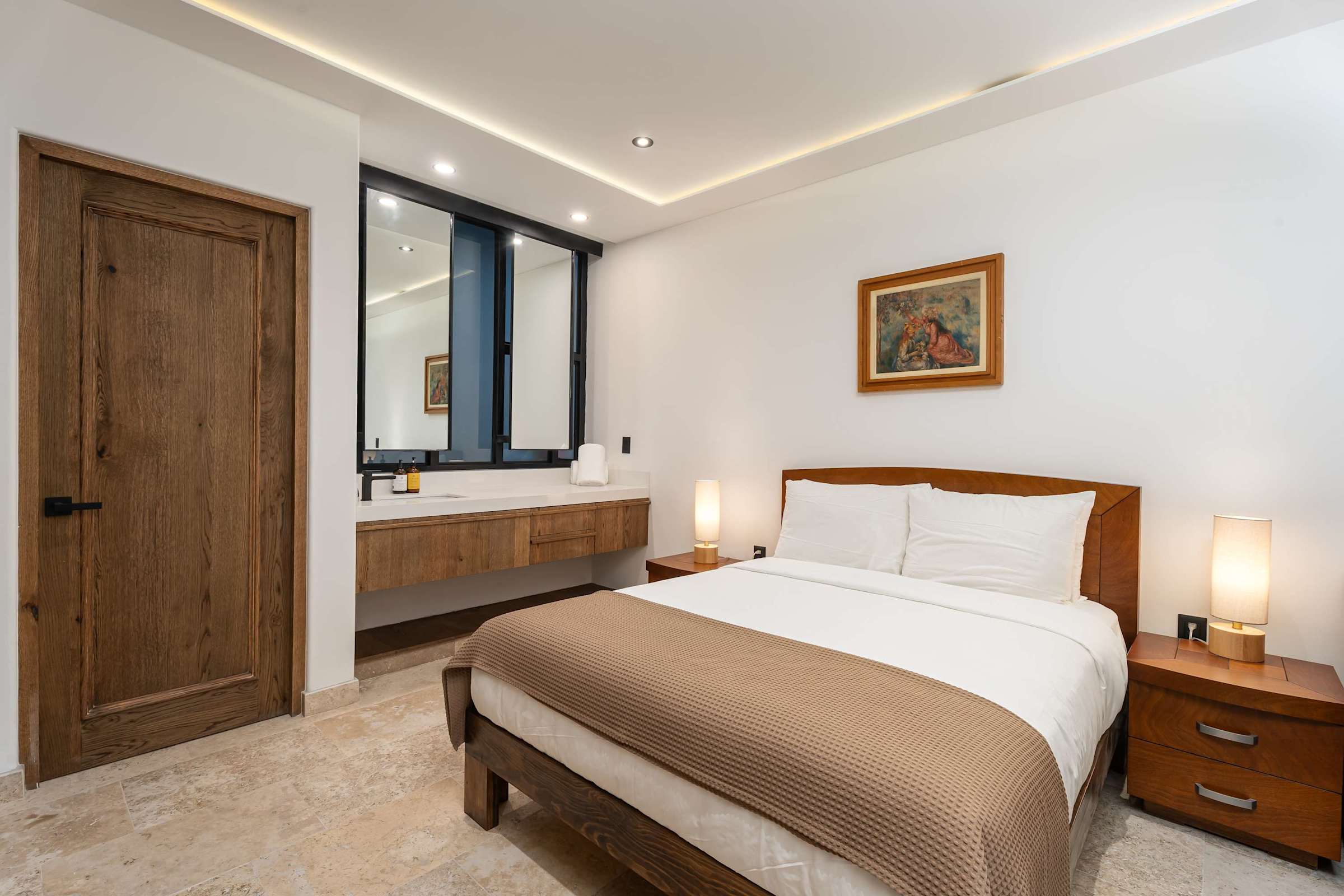 Queen bedroom with marble floors, bathroom vanity, and natural light
