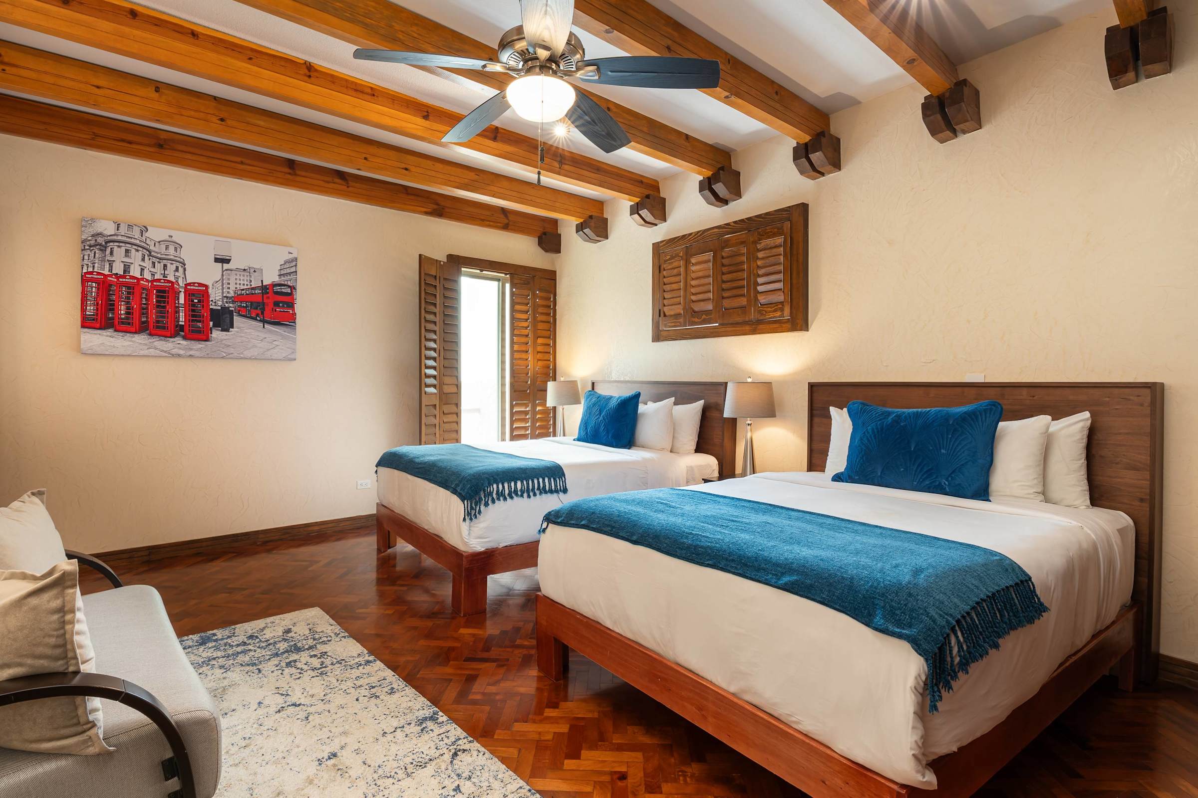 Guest bedroom with two double beds and wood beam ceiling