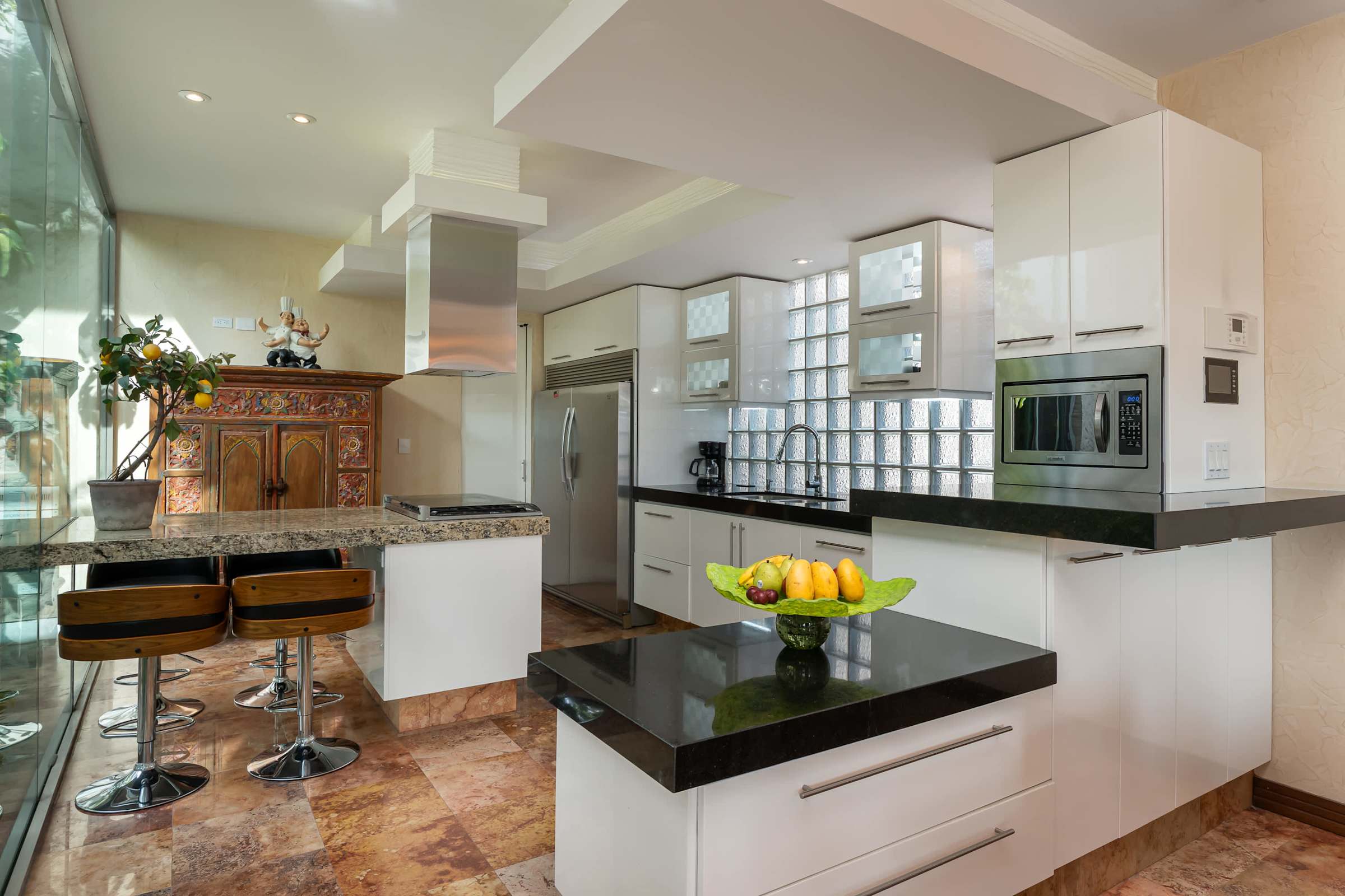 Kitchen with white cabinets and bar seating