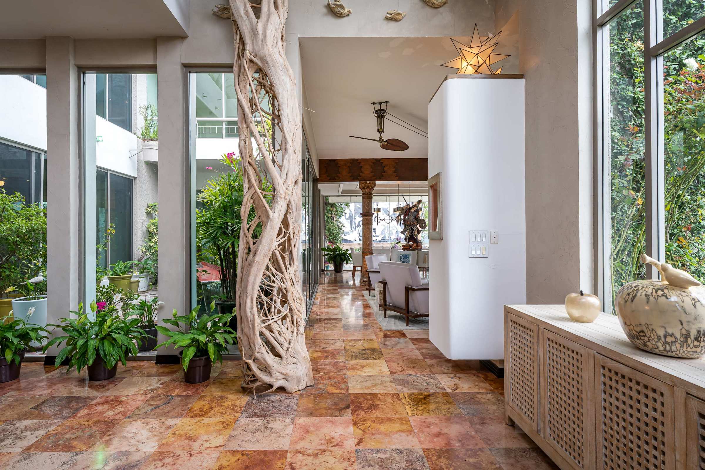 Bright entry foyer with floor to ceiling windows and plants