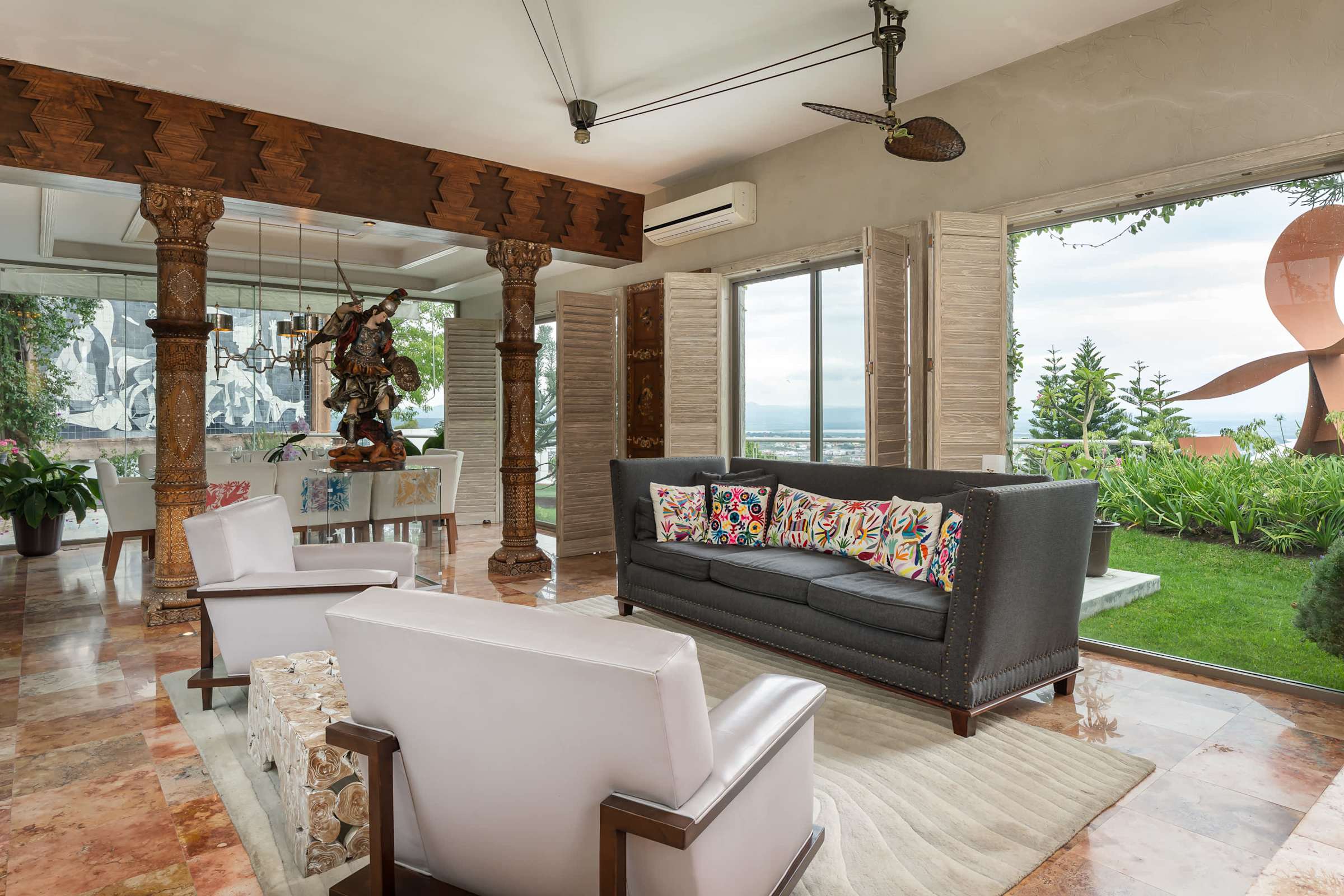 Living room seating area with sculptural artwork and garden views
